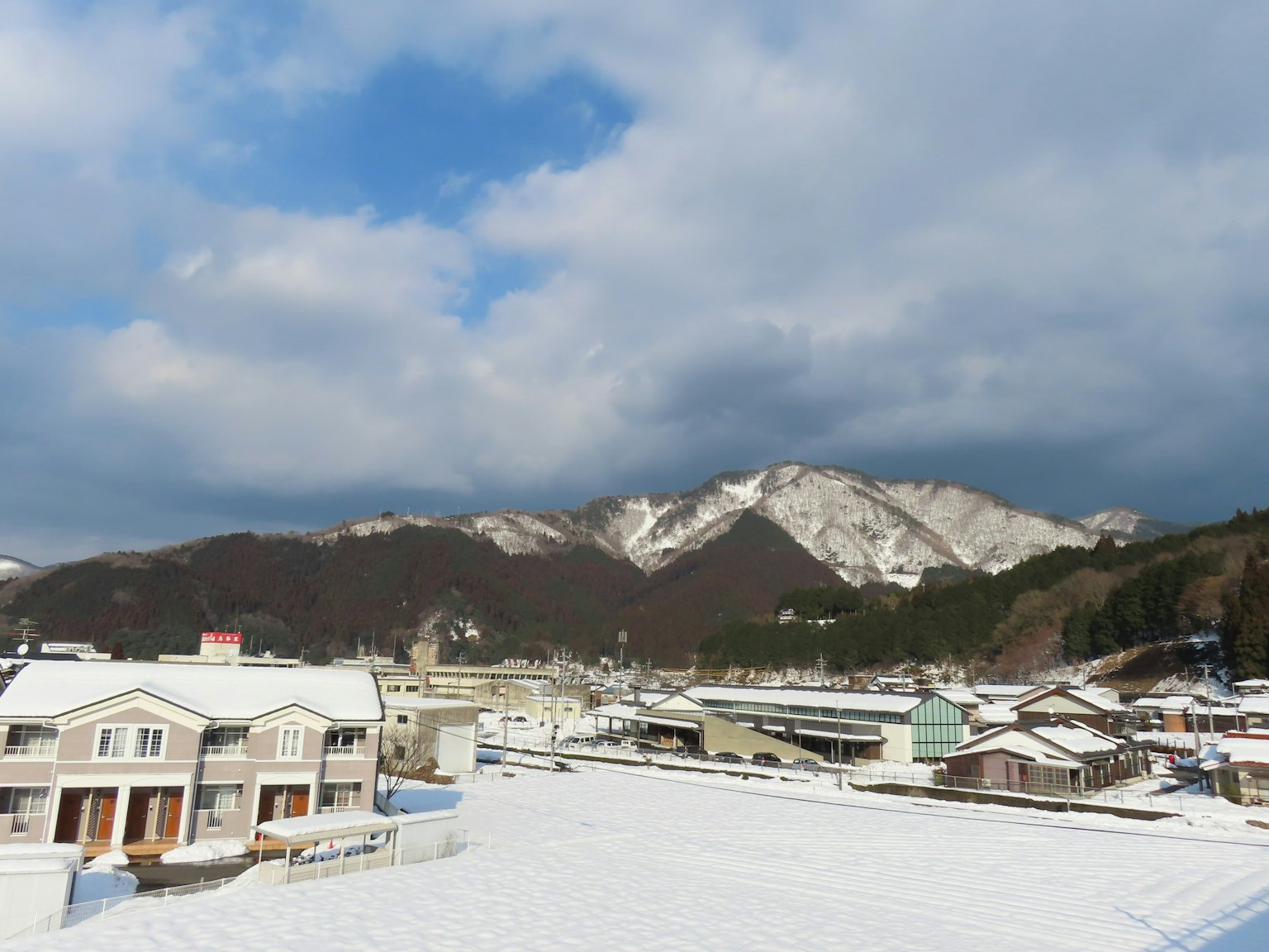 Snow-covered town with mountains in the background
