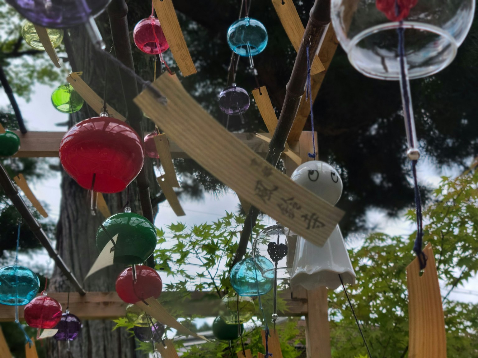 Des carillons colorés suspendus avec une décoration de fantôme blanc visible