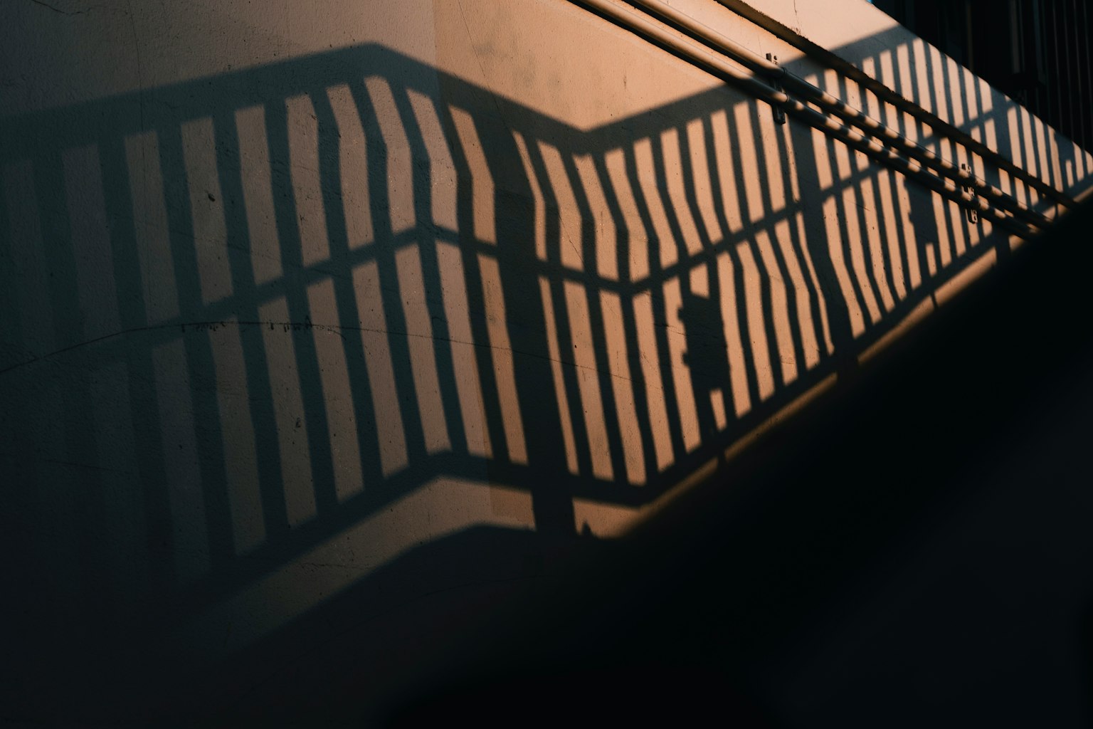 Shadow of a staircase railing cast on a wall