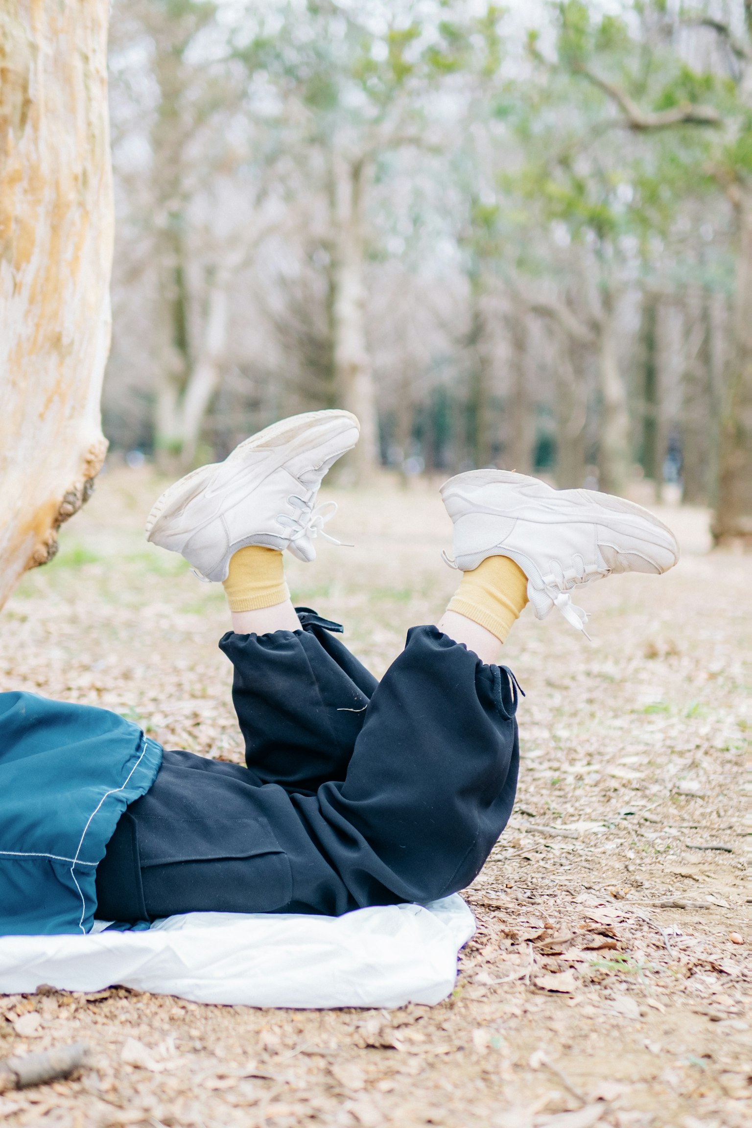 Kaki anak dengan sepatu putih beristirahat di luar di hutan