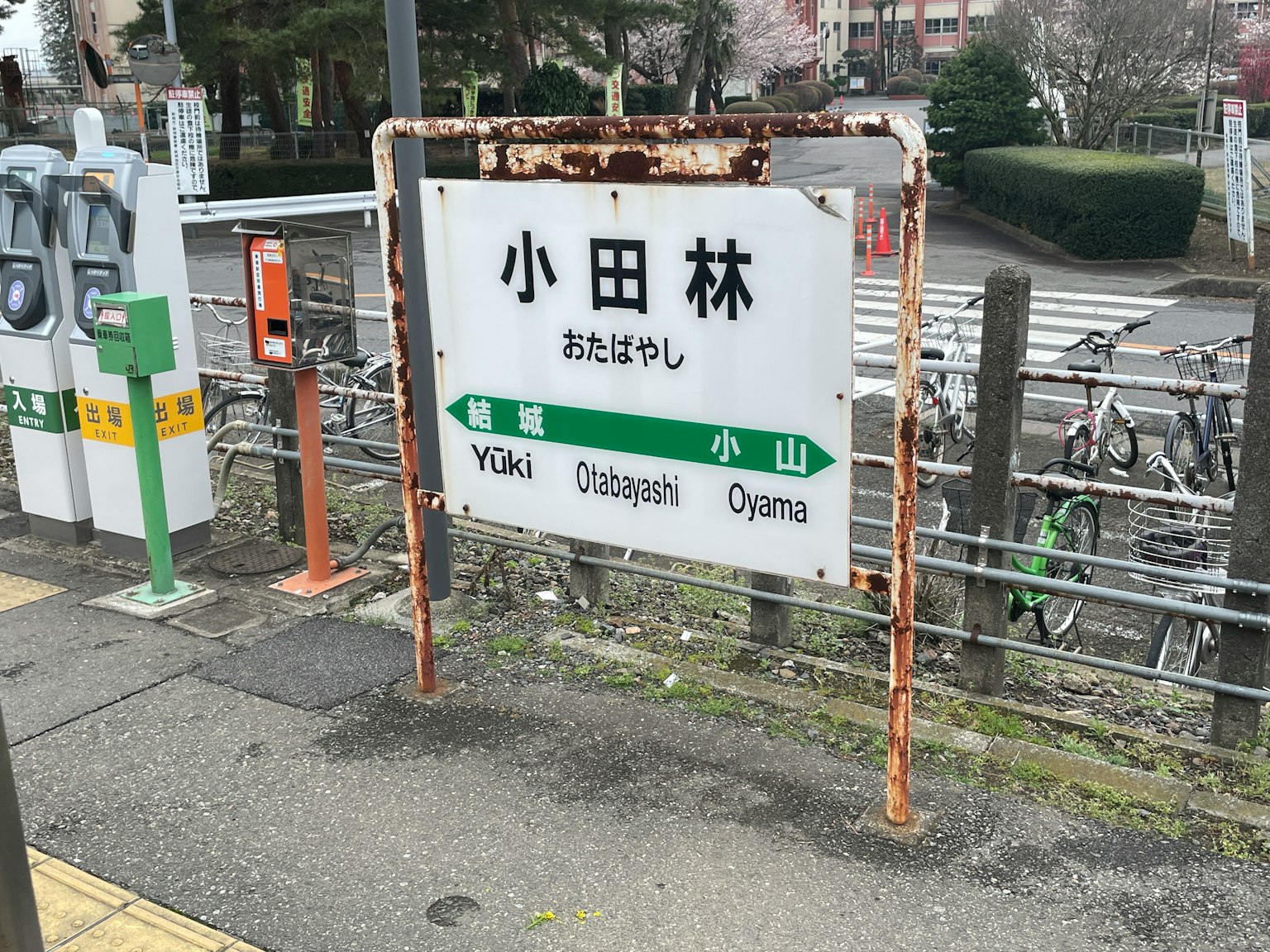 Schild der Station Odabashi mit rostigen Kanten und Fahrrädern in der Nähe