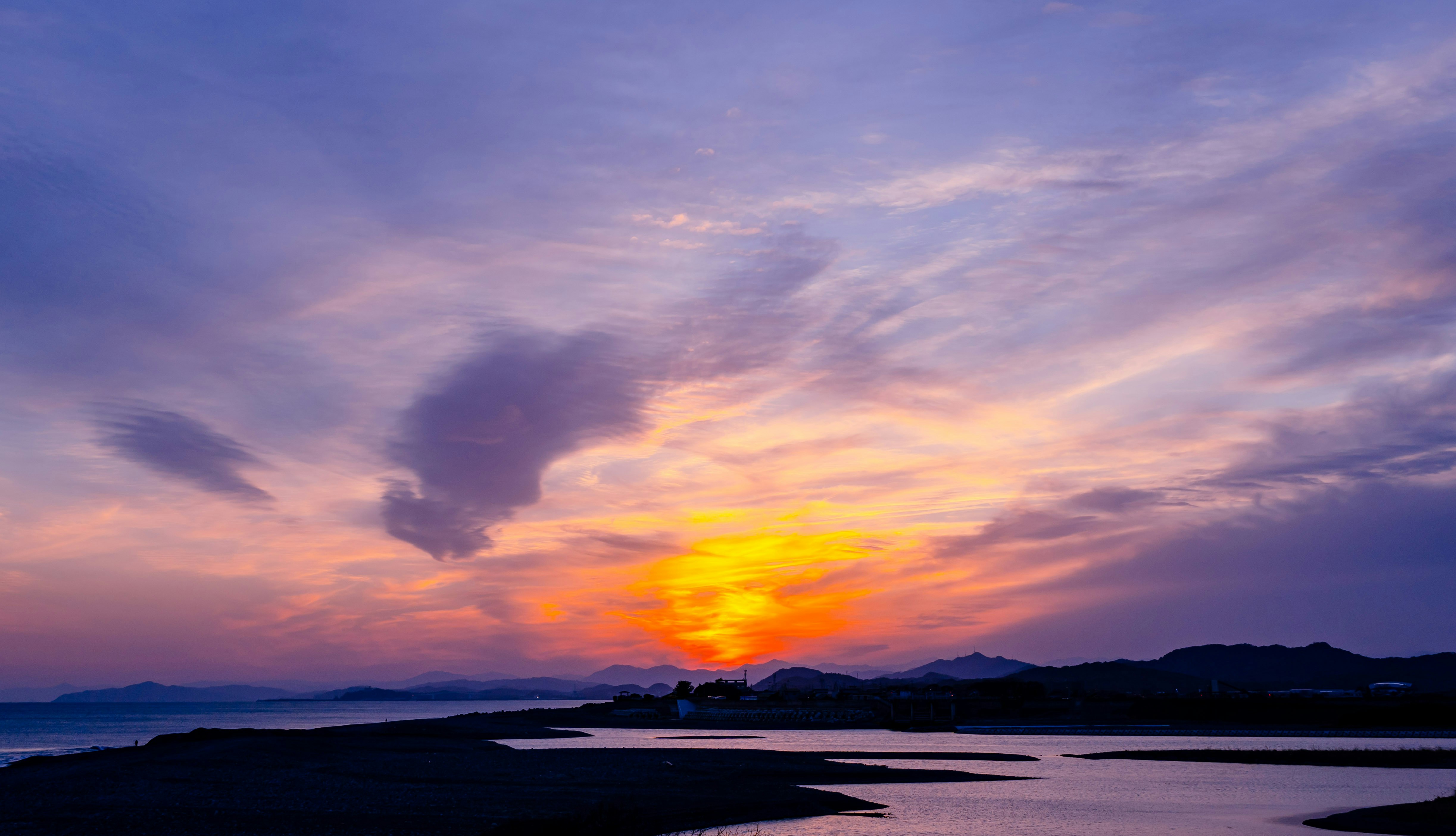 夕焼けの海岸と水平線に広がる雲