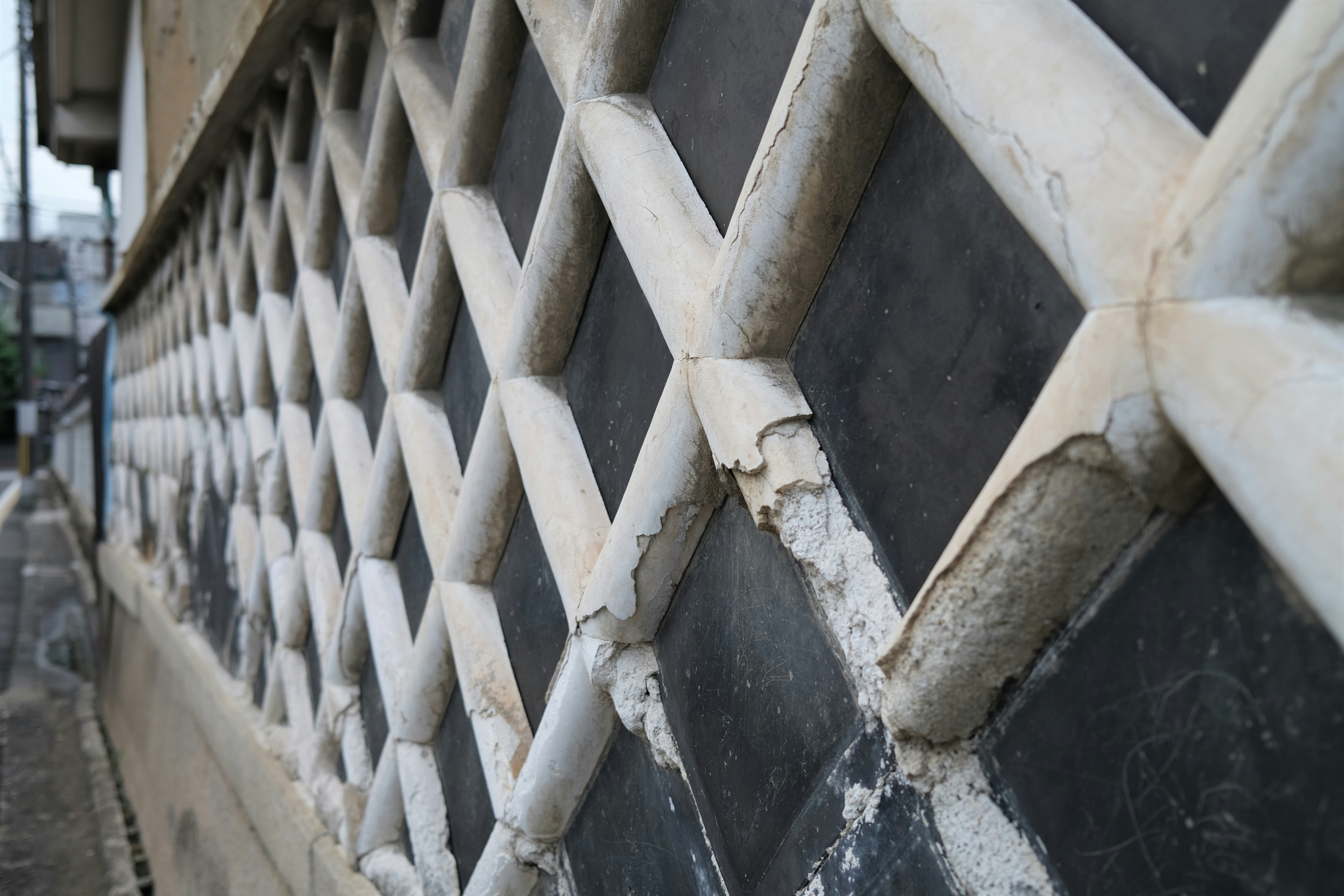 texture di un passaggio stretto lungo un muro a griglia in pietra e cemento