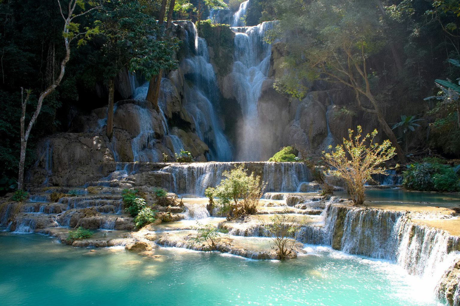 Schöner Wasserfall, der in einen türkisfarbenen Pool fällt, umgeben von üppigem Grün