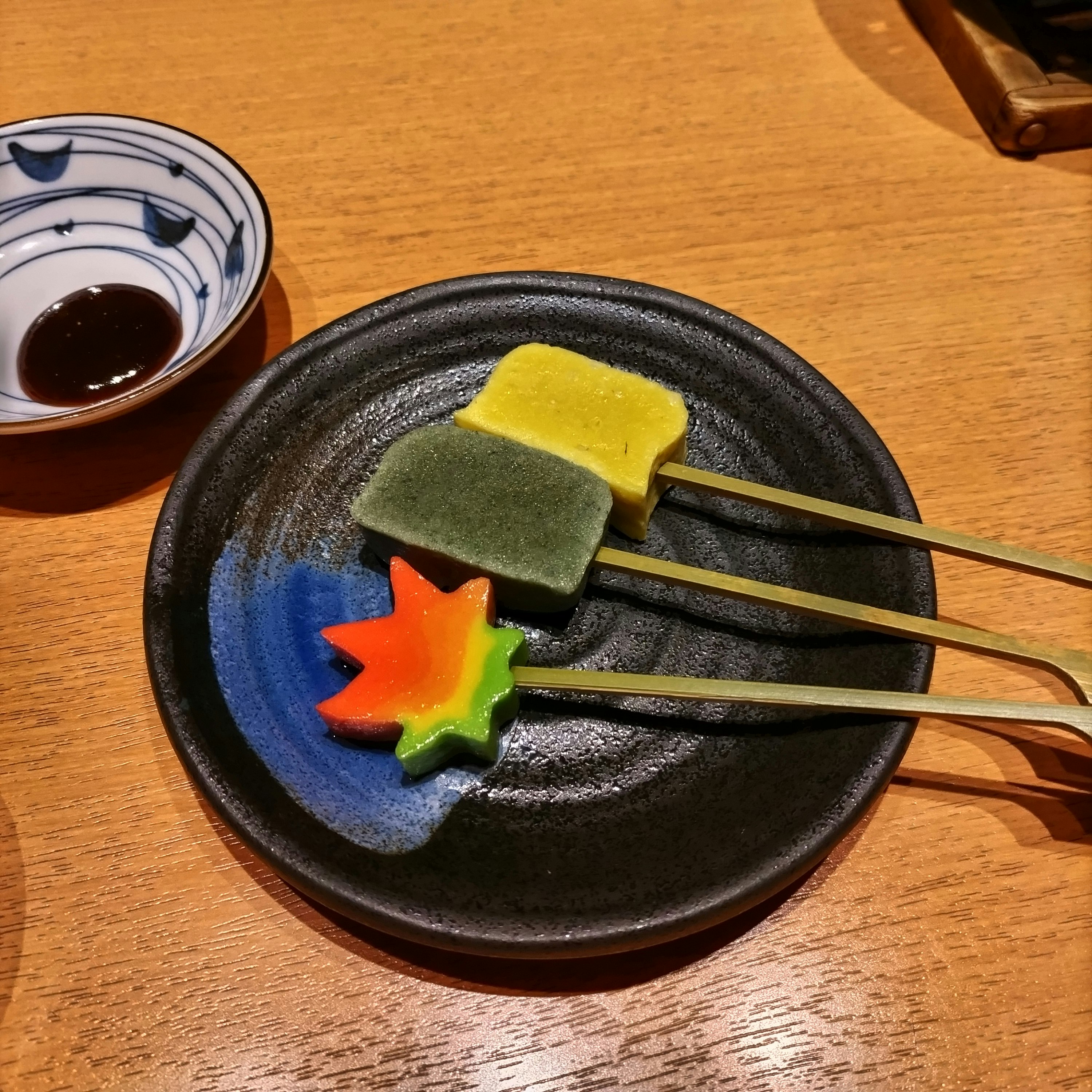 木のテーブル上のカラフルな和菓子とお茶