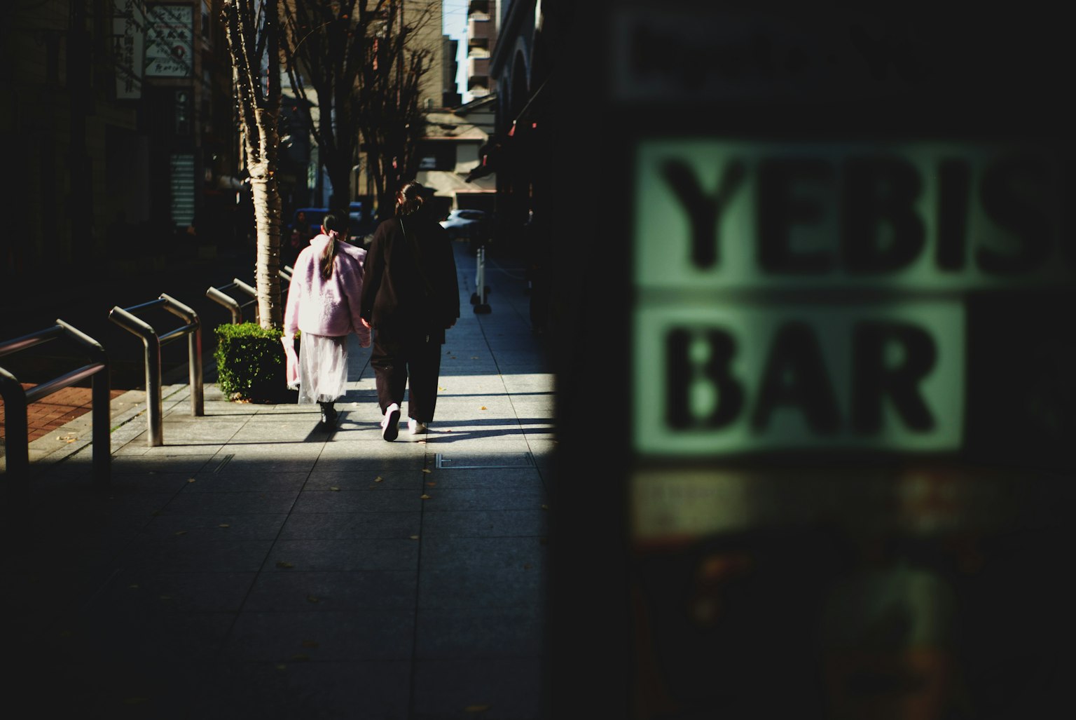 街上行走的人們和YEBIS BAR標誌的場景