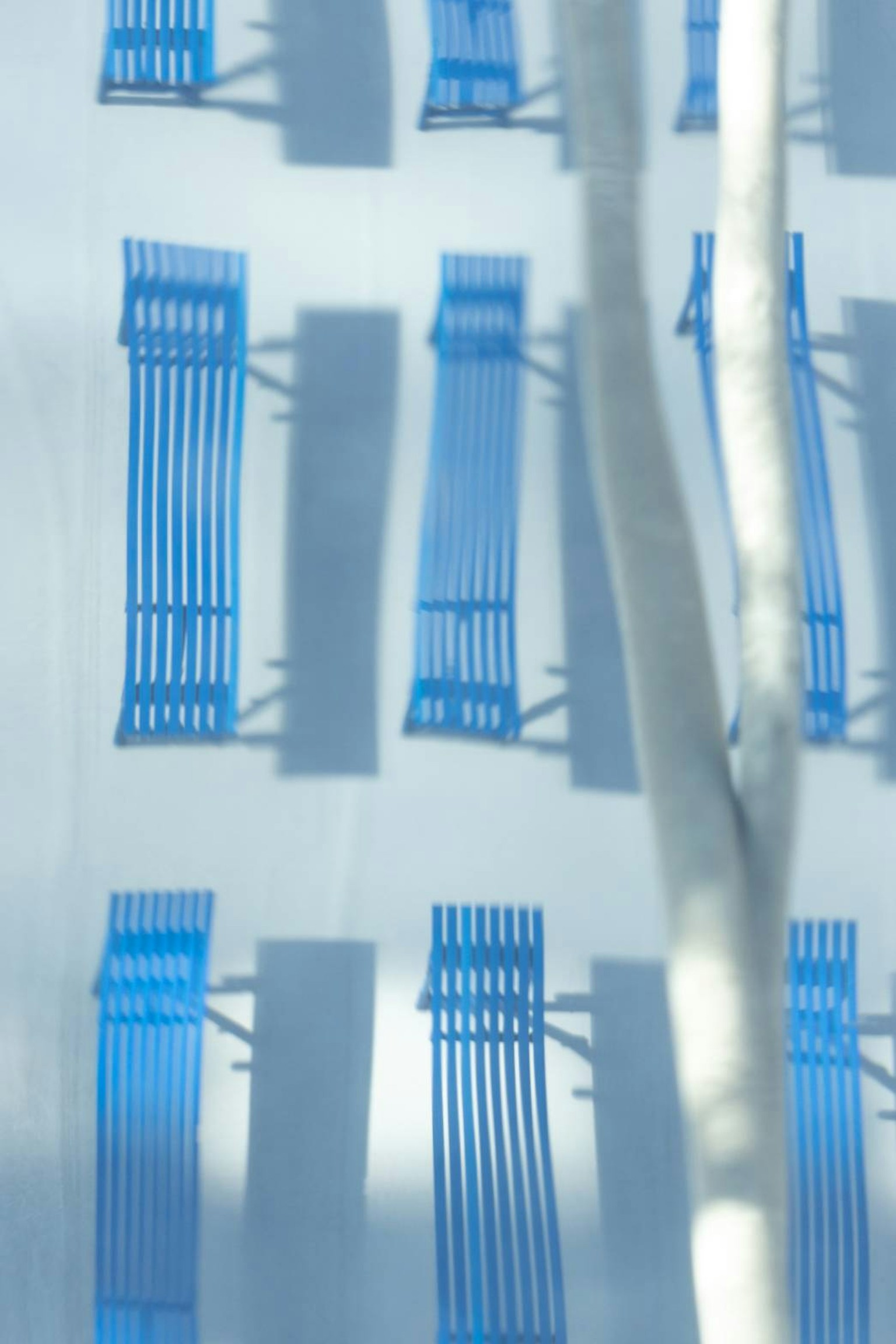 Design moderno semplice con sedie da spiaggia blu disposte su una parete bianca