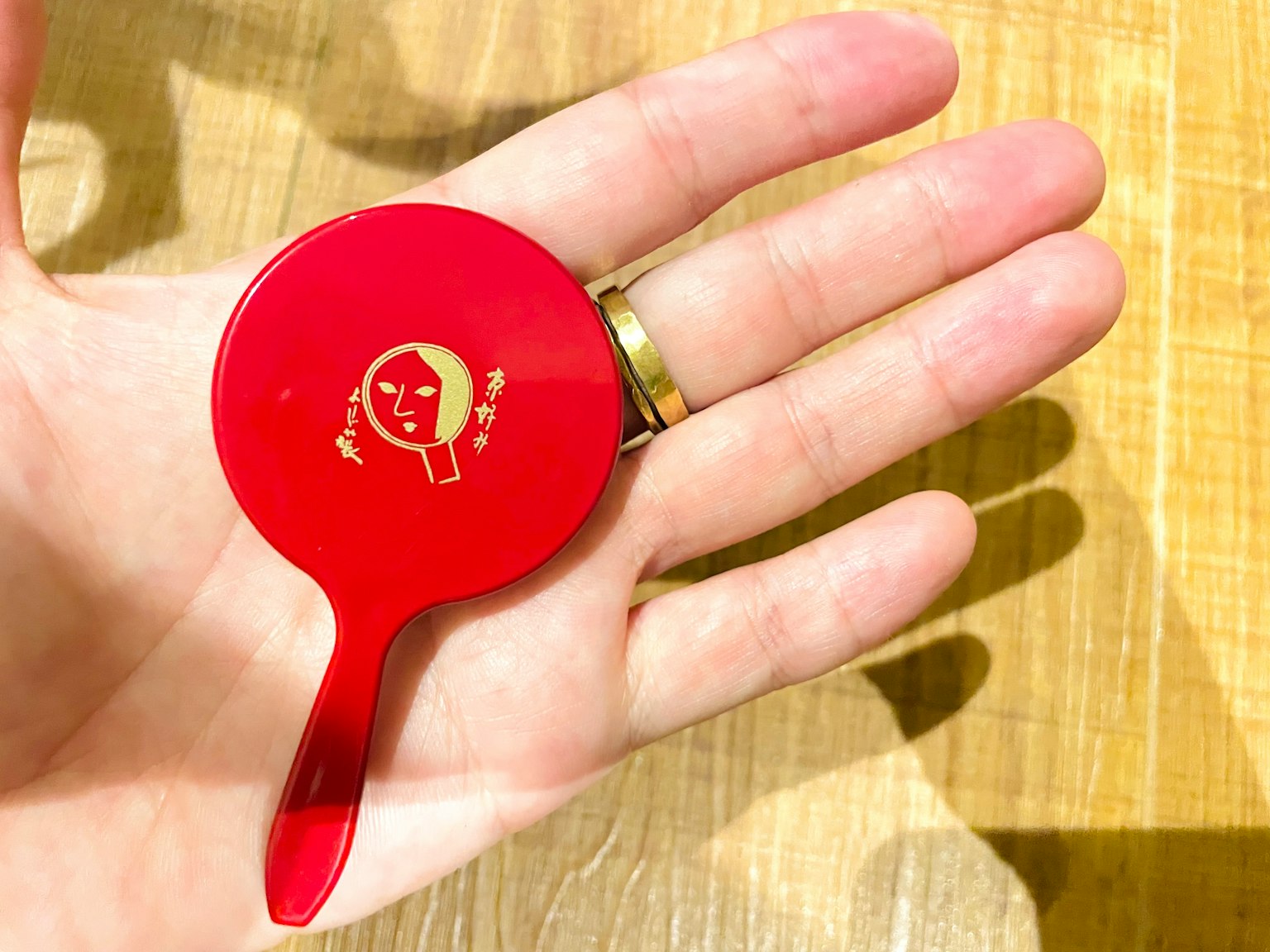 Dispositif d'appel alimentaire rouge en forme de rond tenu dans la main