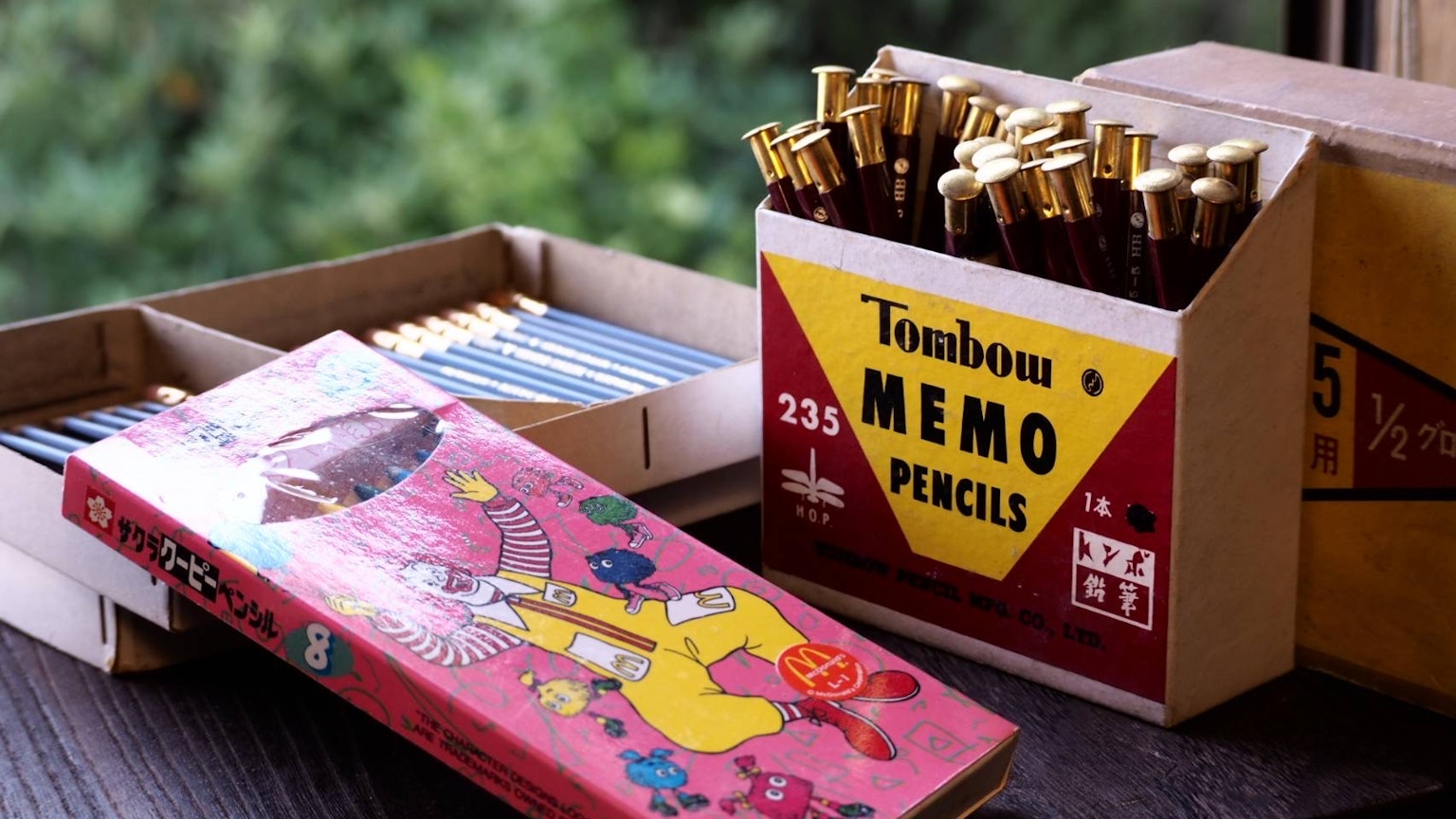 一盒Tombow Memo鉛筆和一本色彩繽紛的書展示在一起
