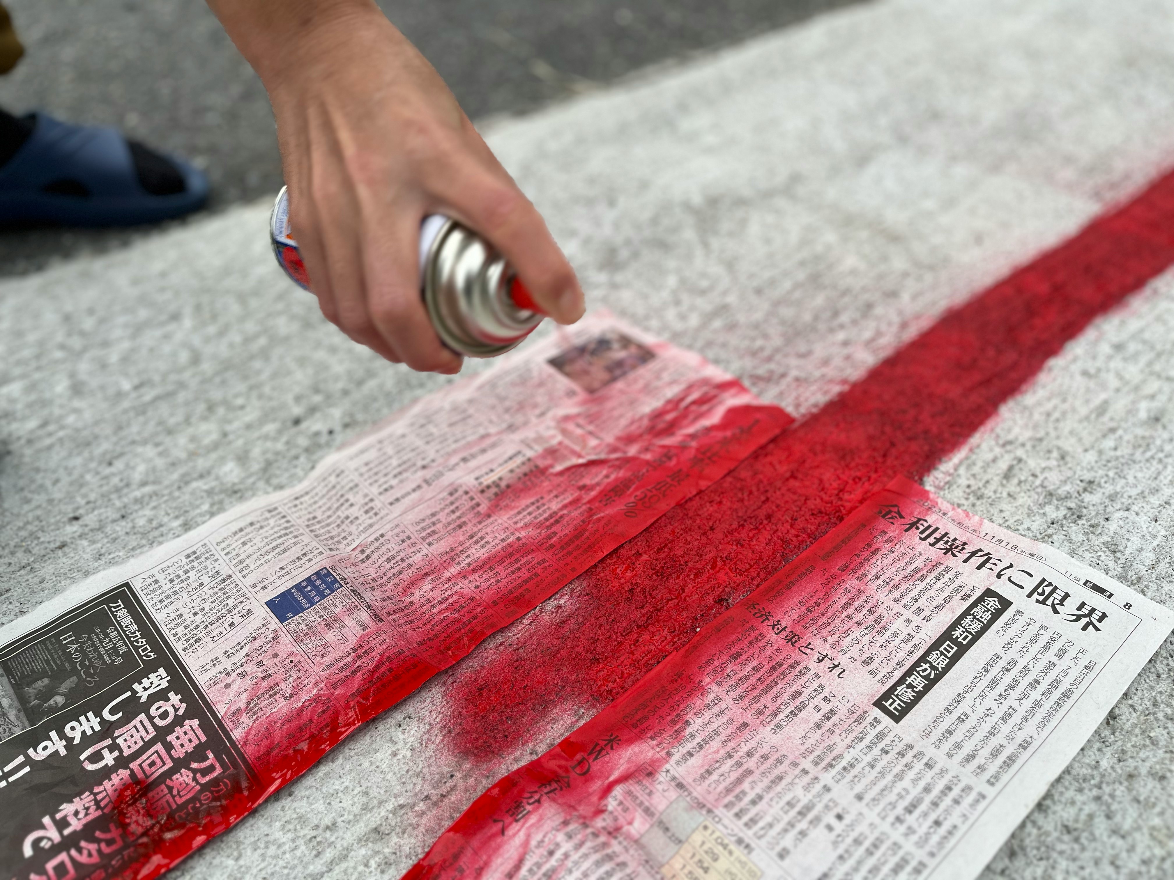 tangan membuka koran yang dibungkus kain merah