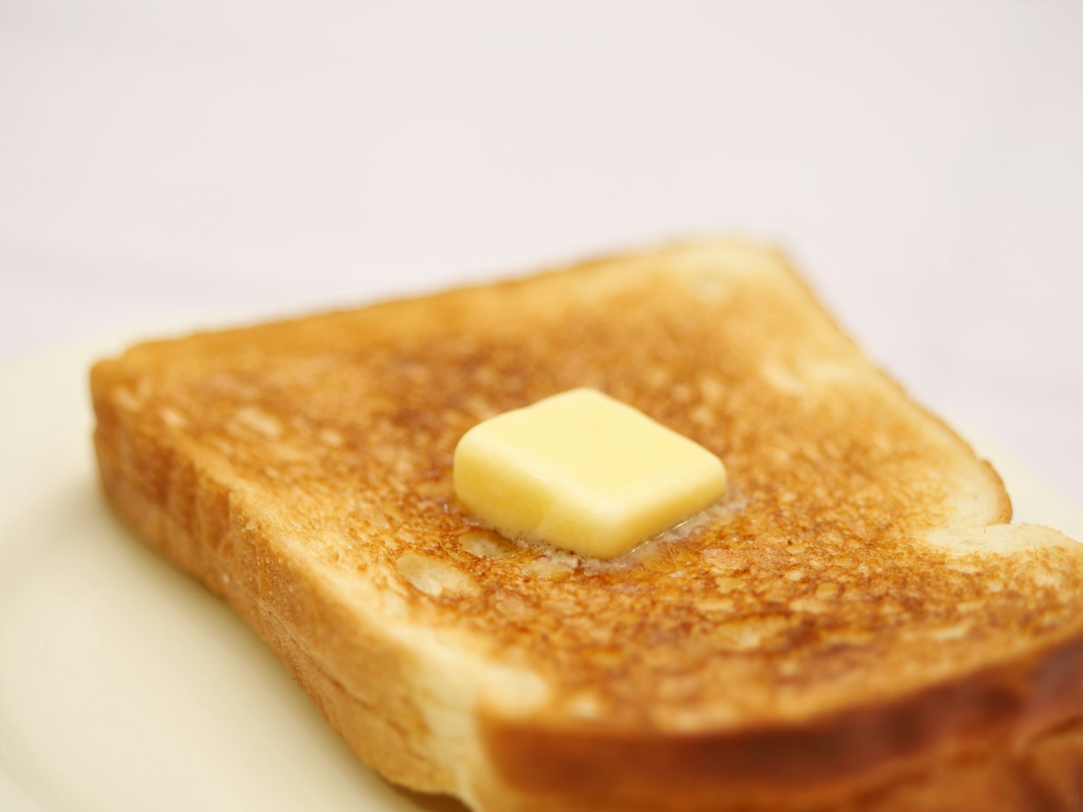 Một lát bánh mì nướng với một miếng bơ trên đỉnh