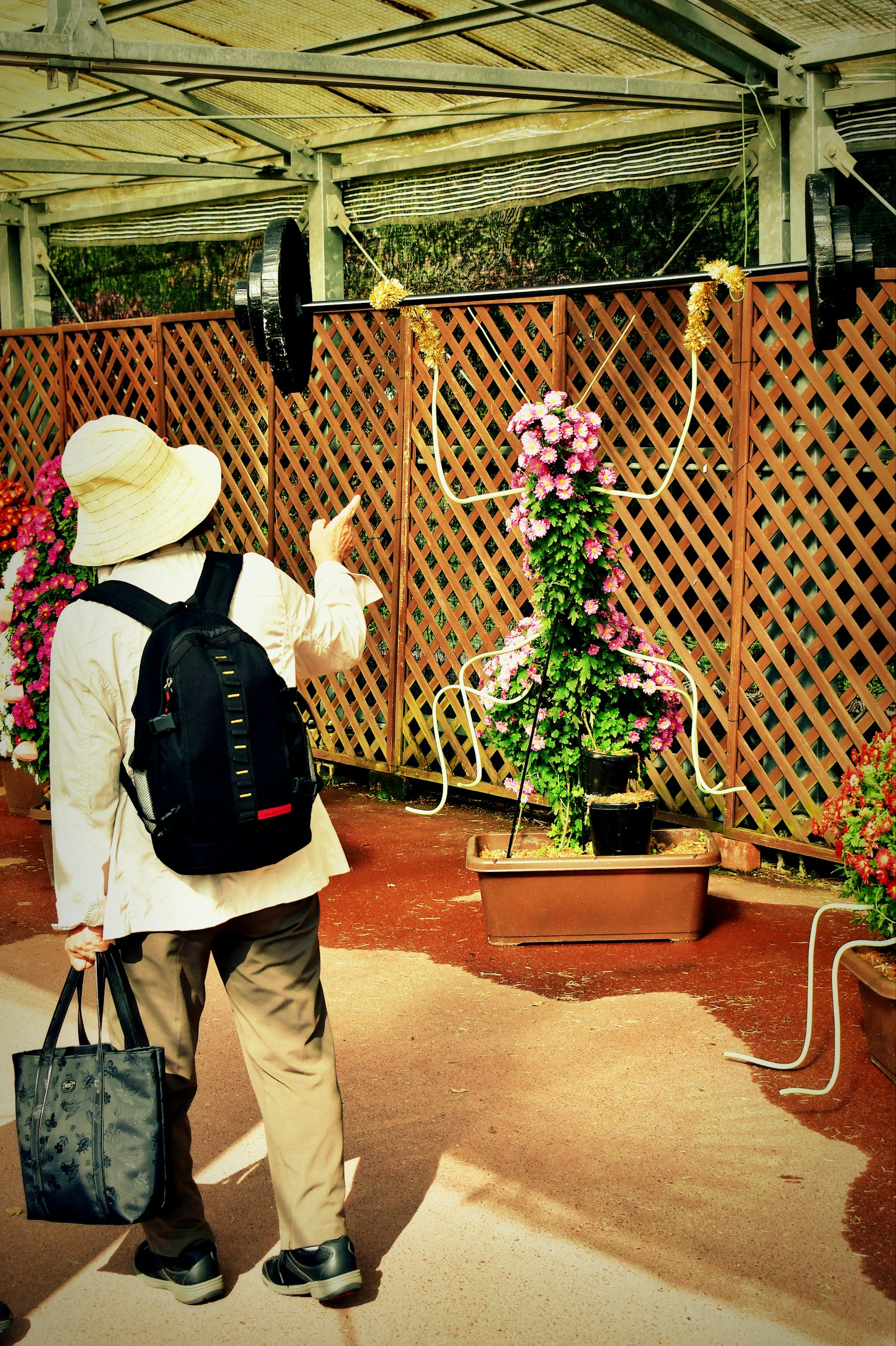 花で装飾されたユニークなオブジェを指さす観光客