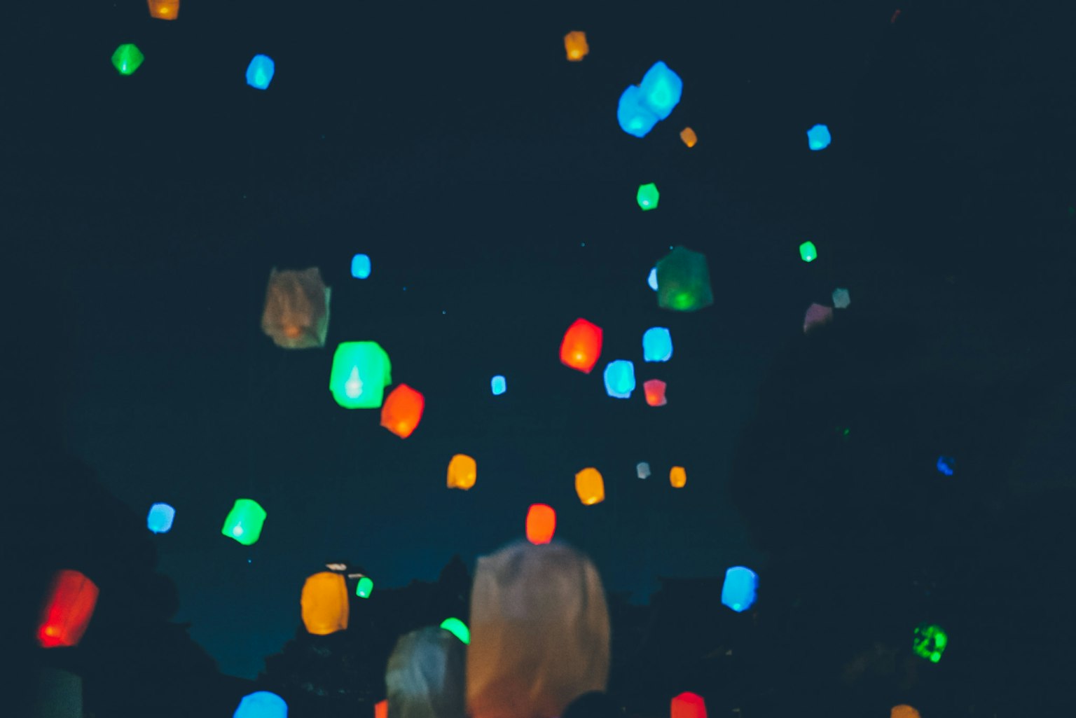 Colorful lanterns floating against a dark background