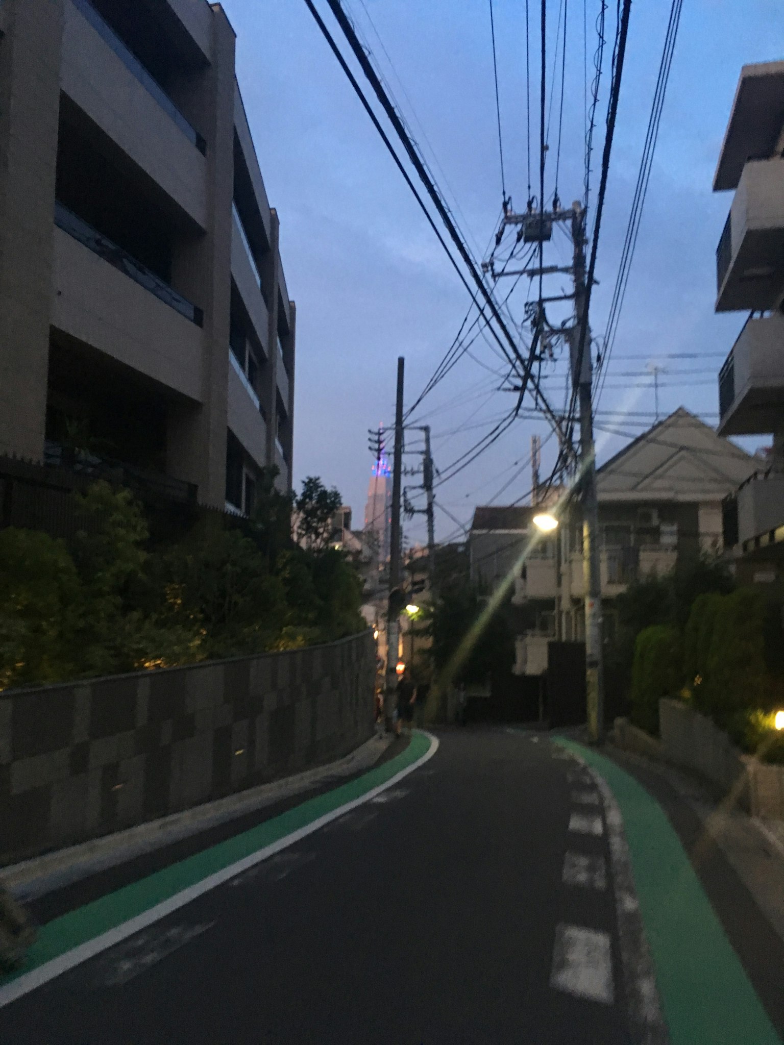 Rue étroite avec des bâtiments et des lignes électriques au crépuscule