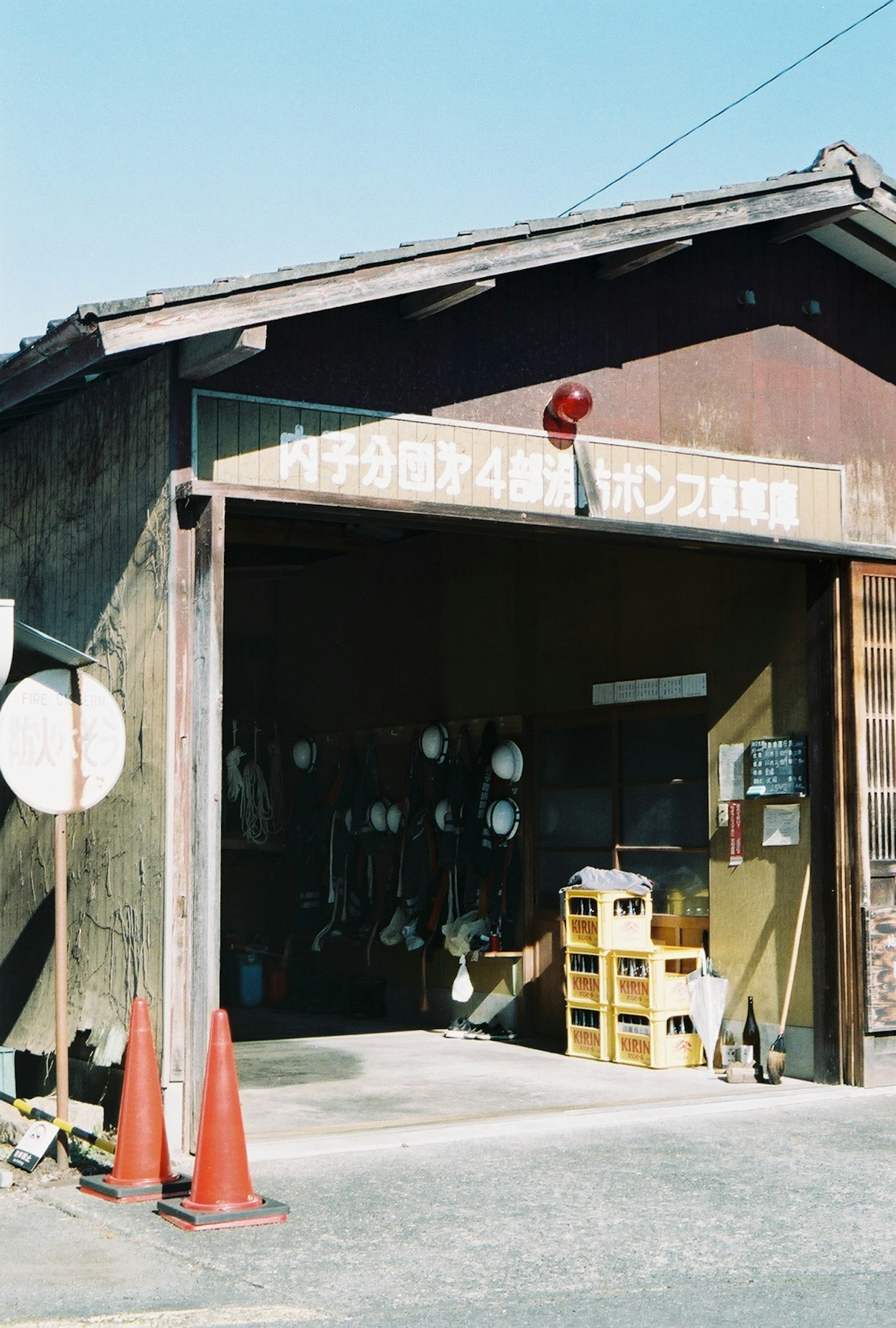 Exterior of an old warehouse featuring a red warning light and orange cones