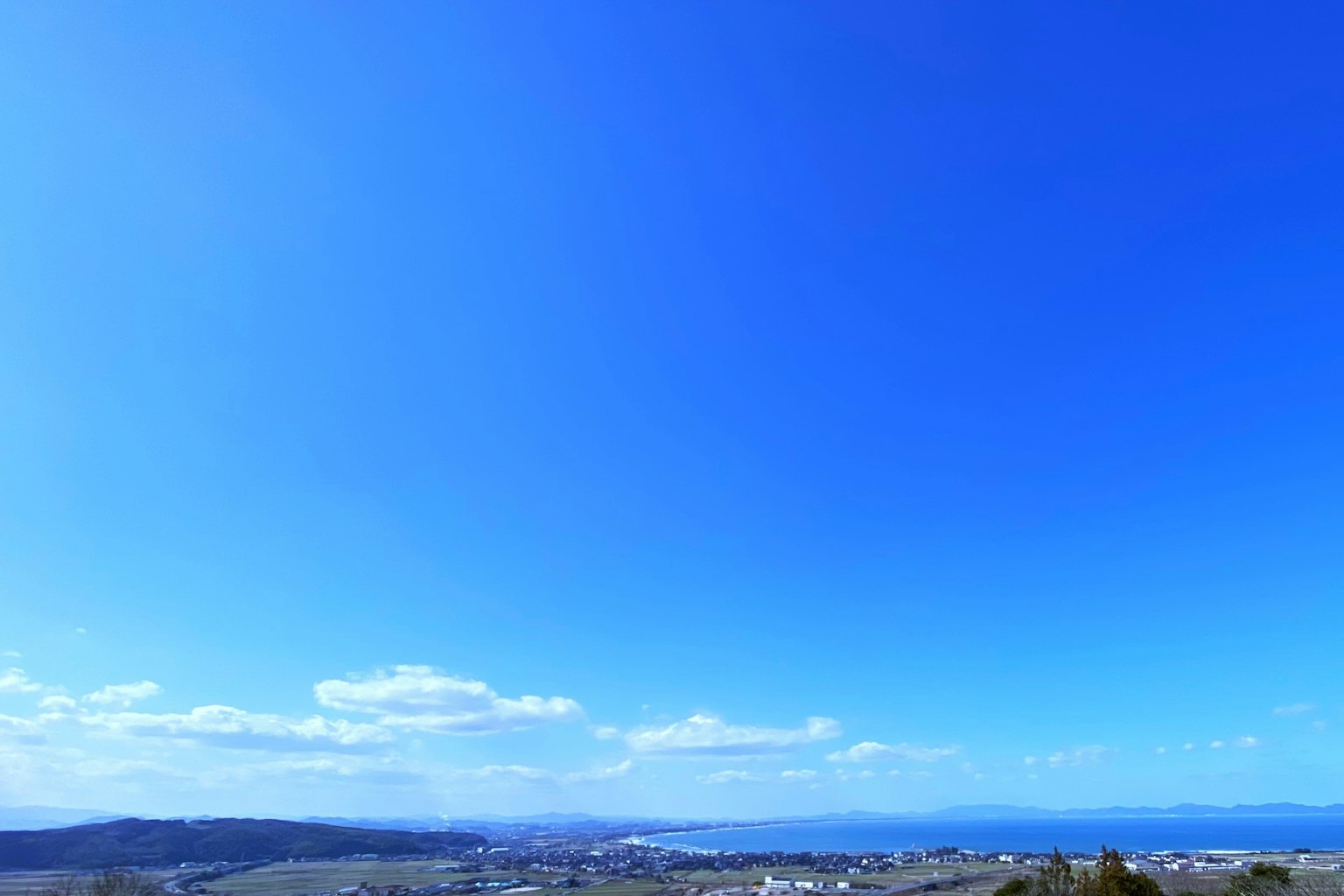 Vast blue sky with scattered clouds