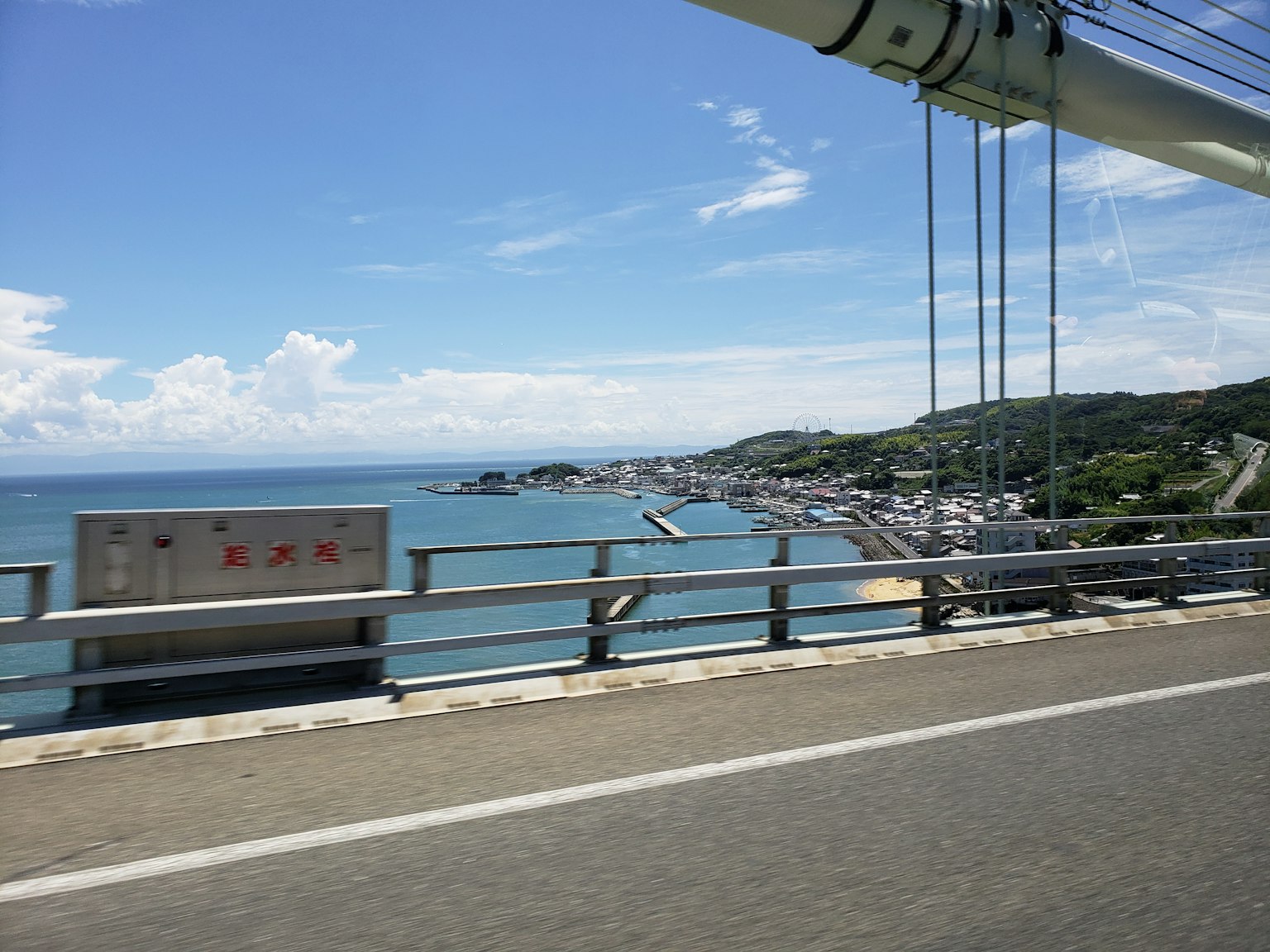 Vista escénica de un puente con océano y cielo azules ciudad visible a la derecha