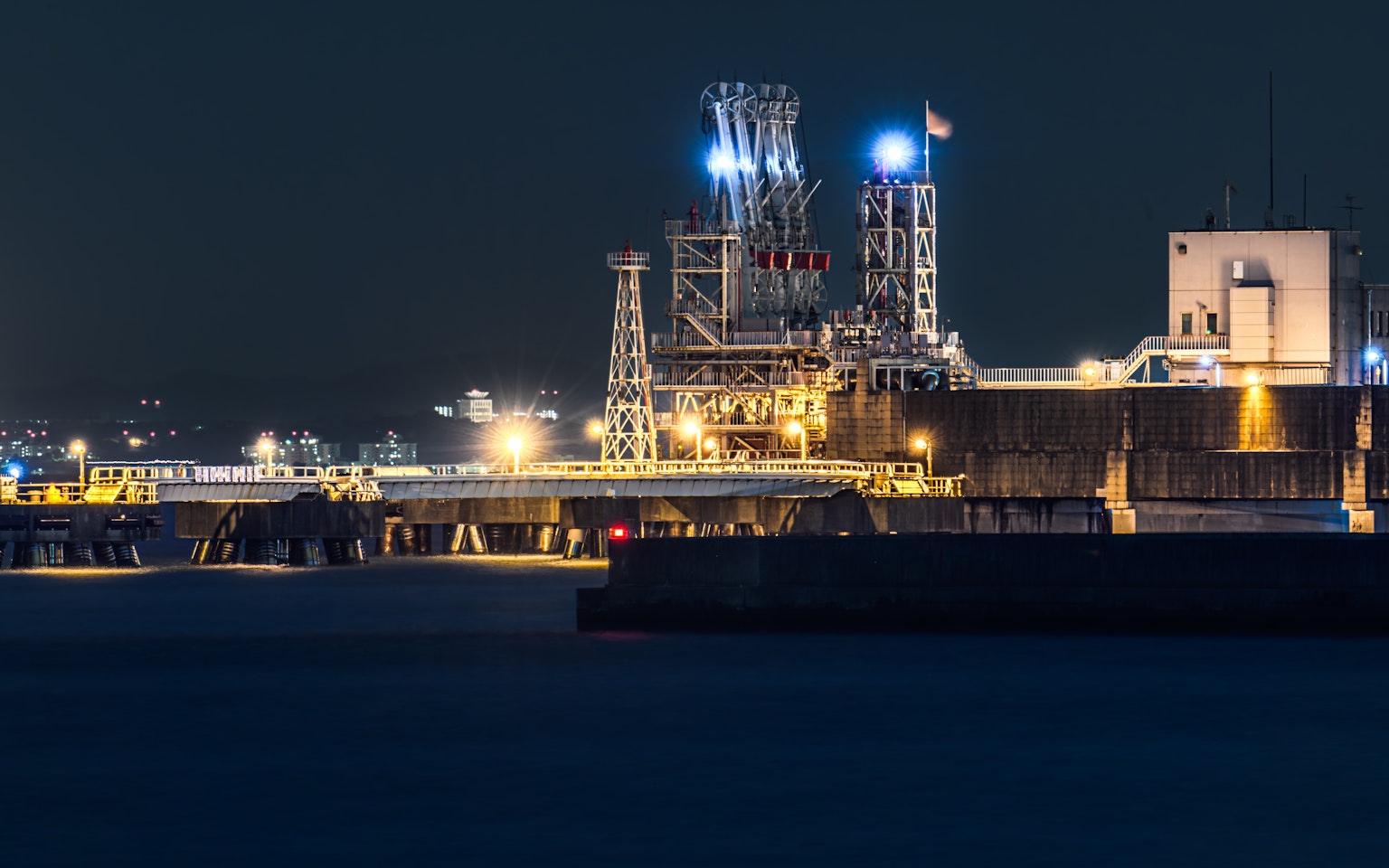 Installation industrielle illuminée la nuit au port