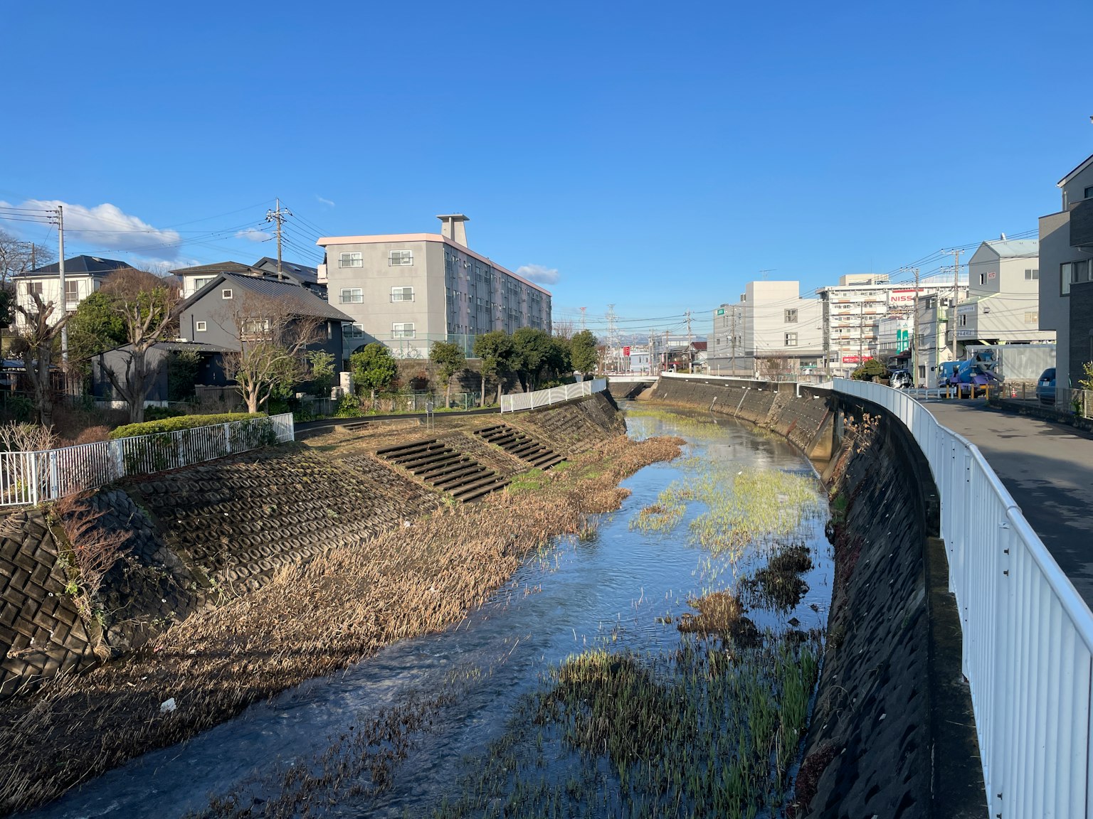 Vista de un río en una zona residencial con cielo azul y edificios