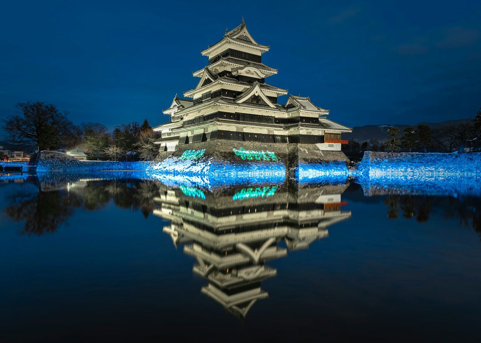 Castello di Matsumoto di notte con riflesso sull'acqua