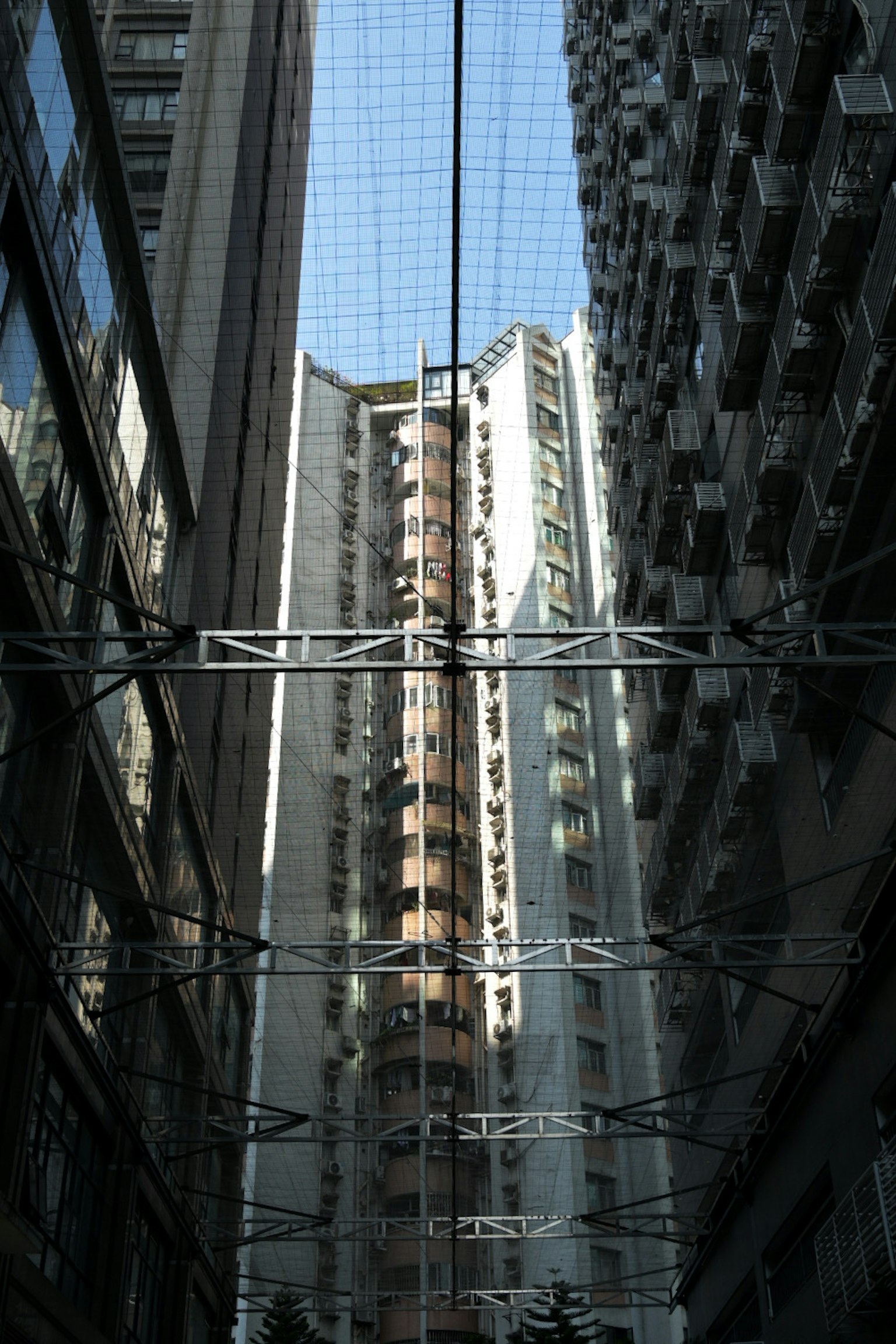 高層ビルの間にある狭い通りの景色 上を見上げると青空が見える