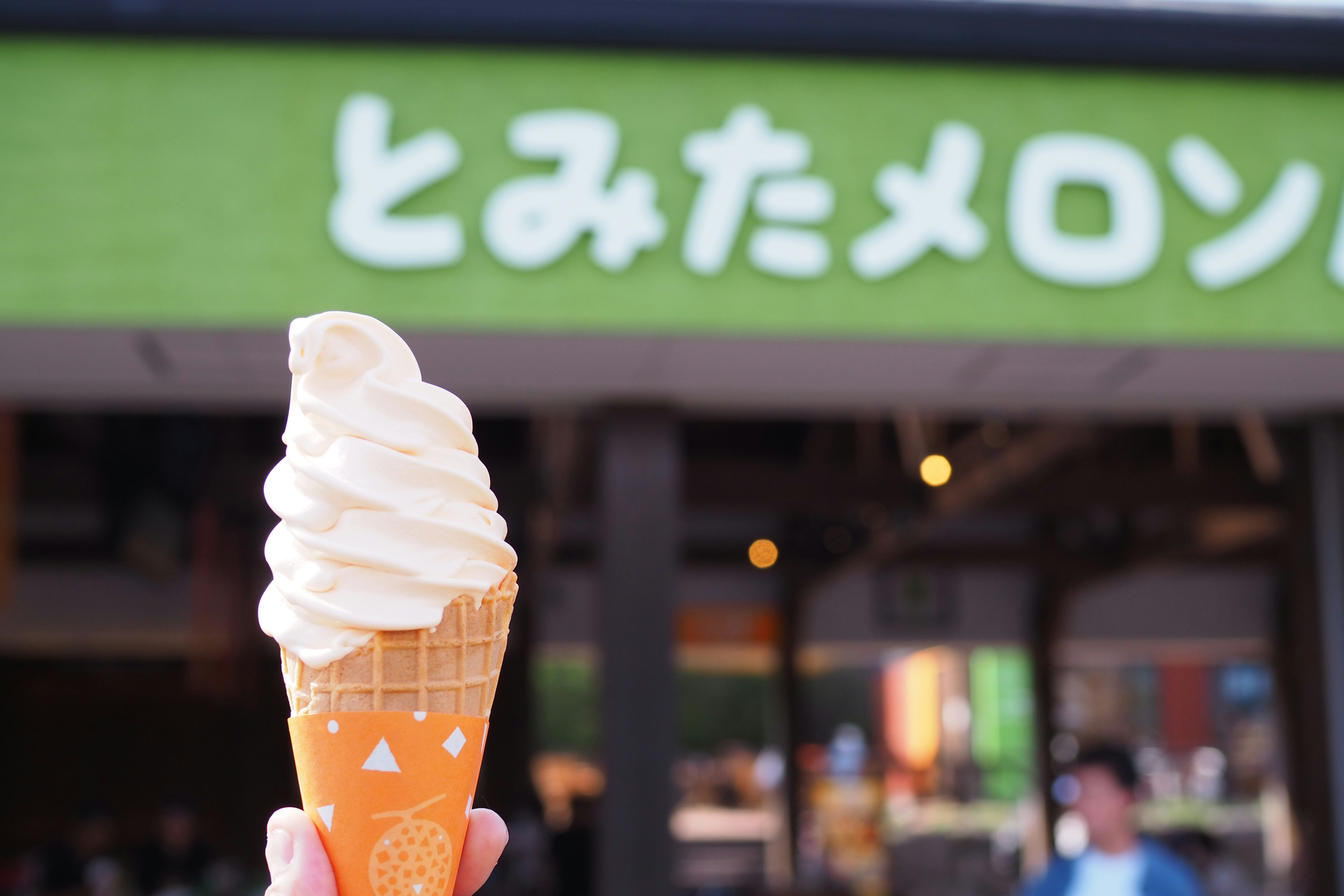 店先で手に持つソフトクリーム