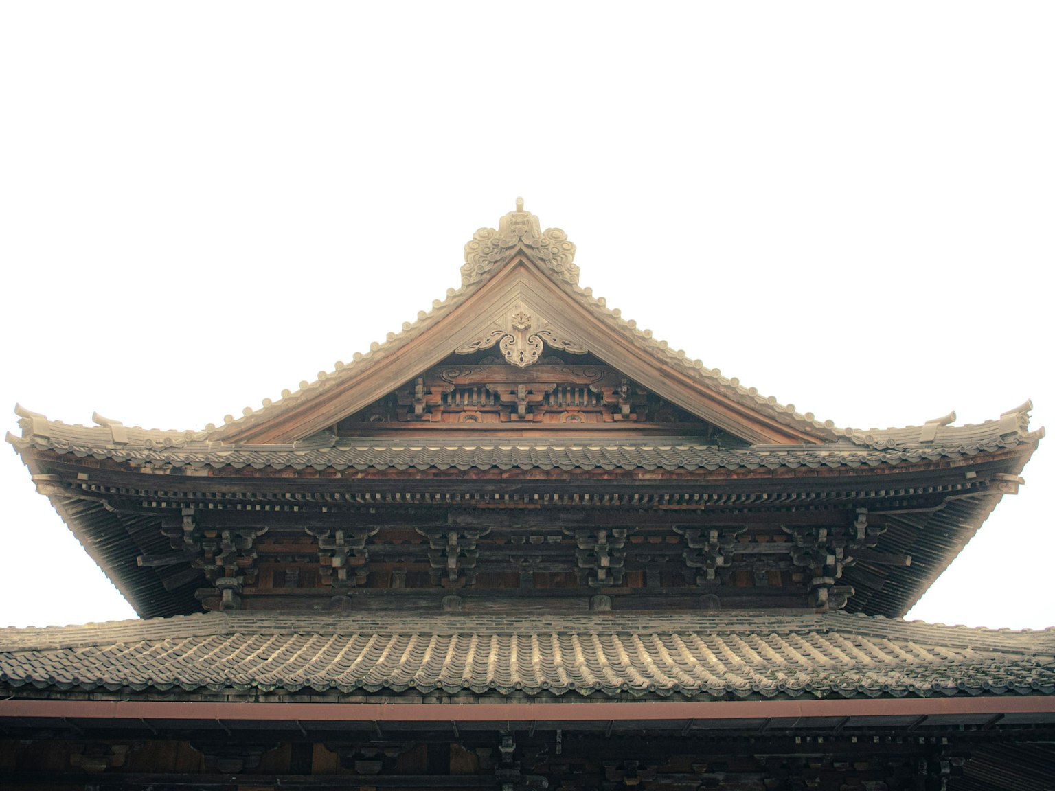 伝統的な日本の寺院の屋根の詳細が見える画像