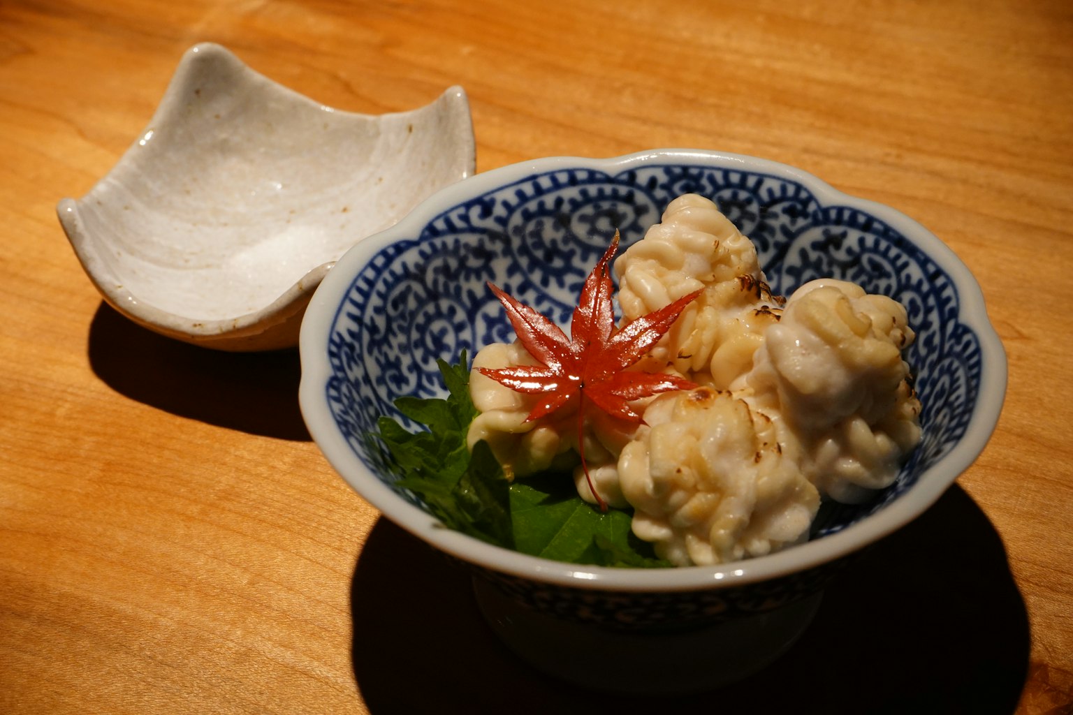Plat de tempura servi dans un bol à motif bleu avec garniture sur une table en bois