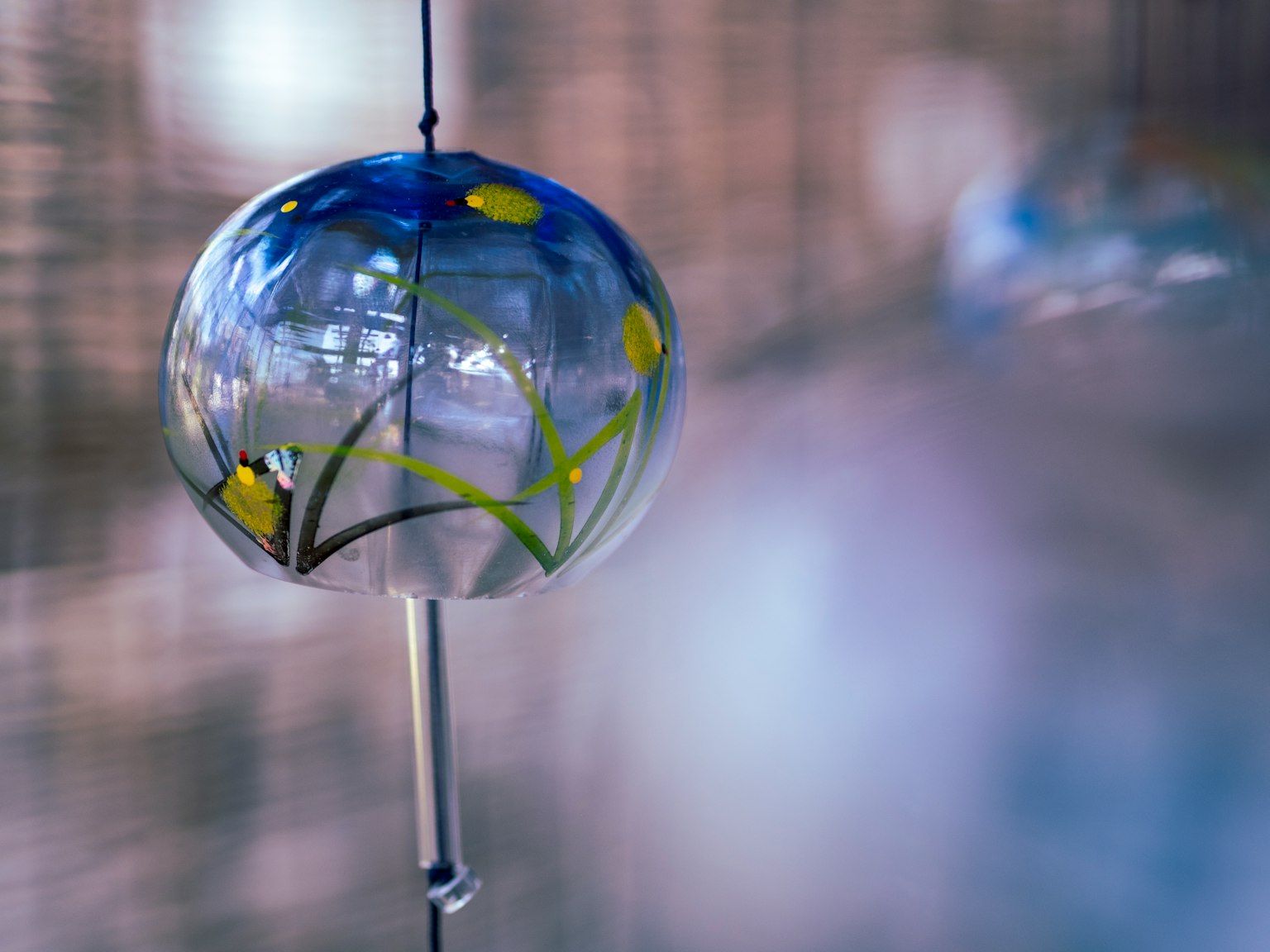 Blue glass wind chime with yellow flower design