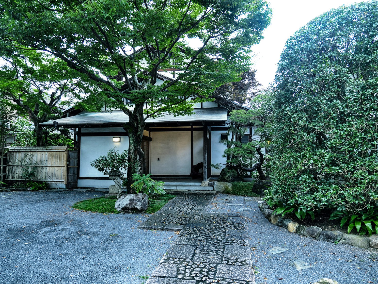 Extérieur d'une maison japonaise traditionnelle entourée d'un jardin