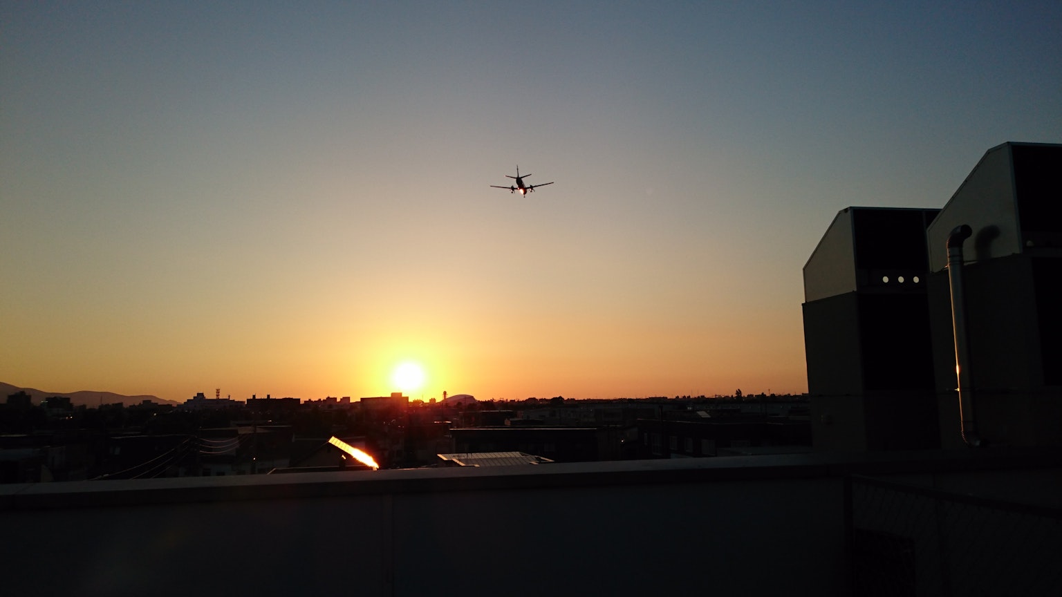 Aereo che vola contro un tramonto