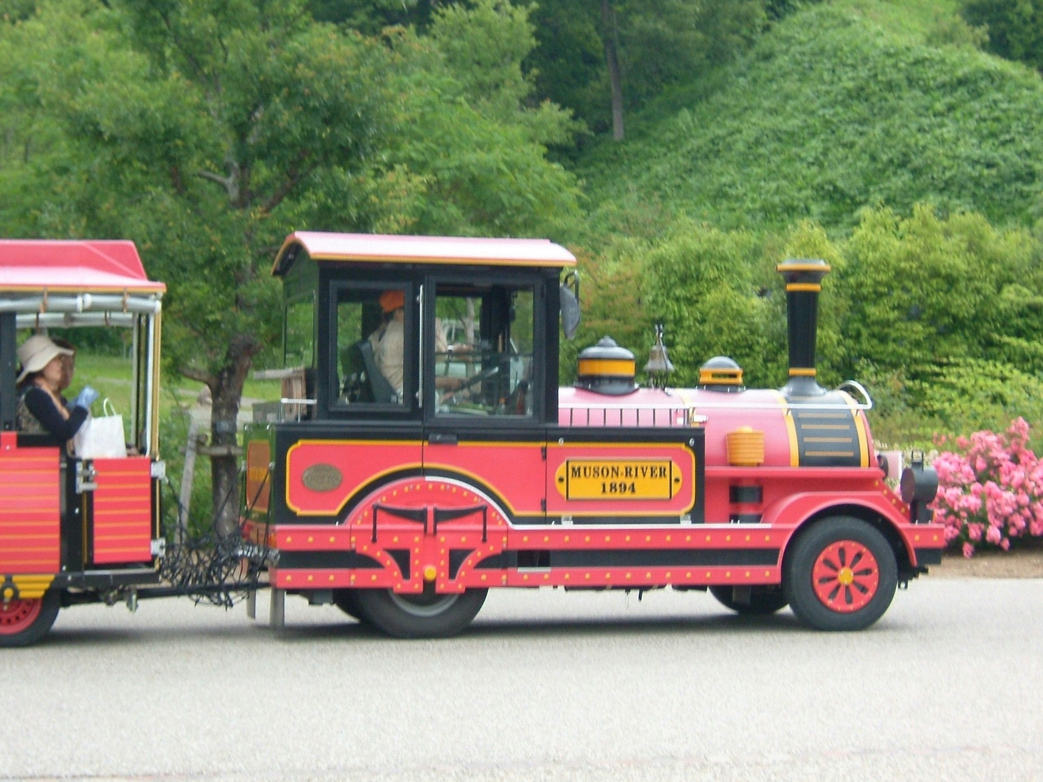 緑の公園を走る赤いミニ列車