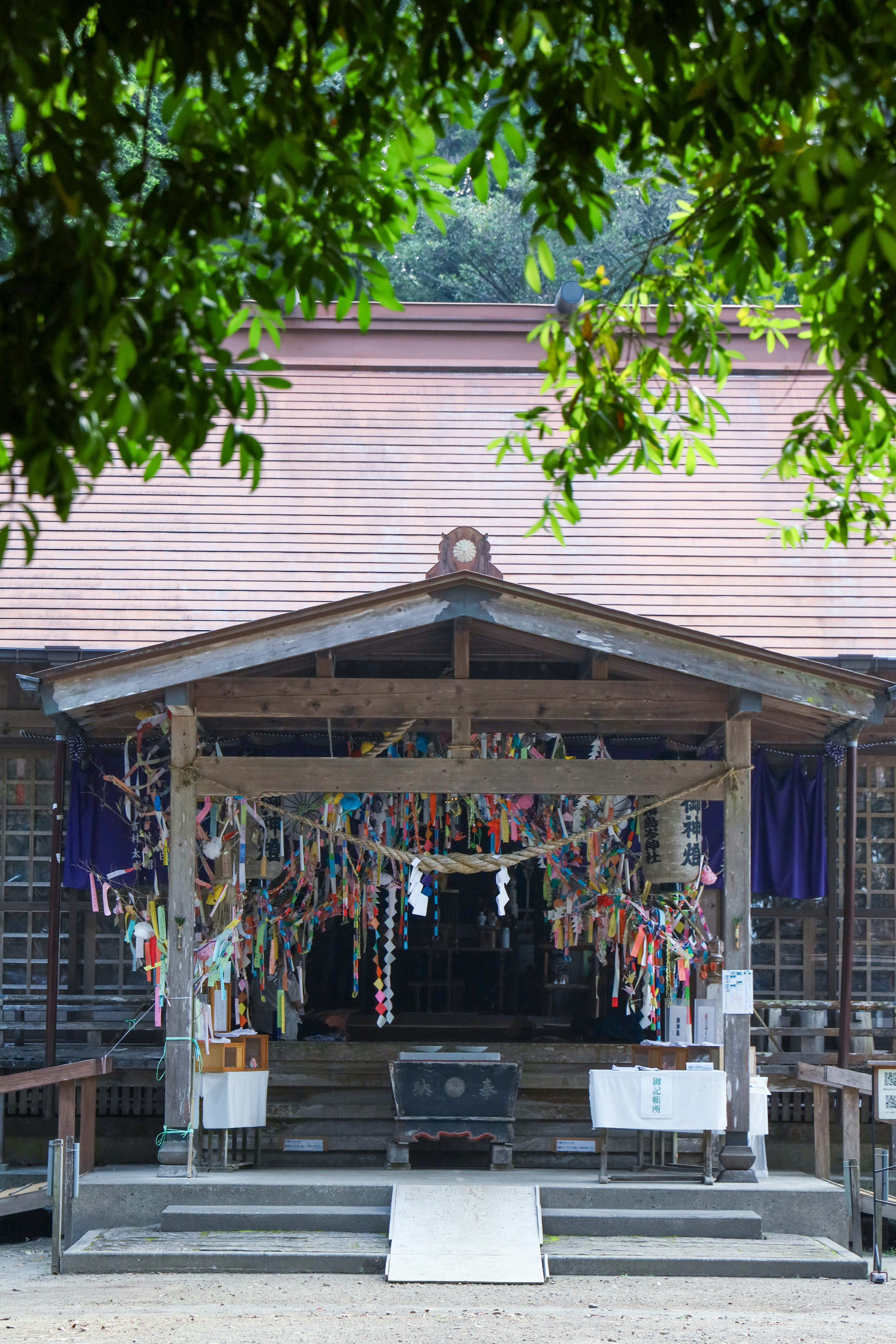 伝統的な神社の建物と色とりどりの短冊が飾られた風景