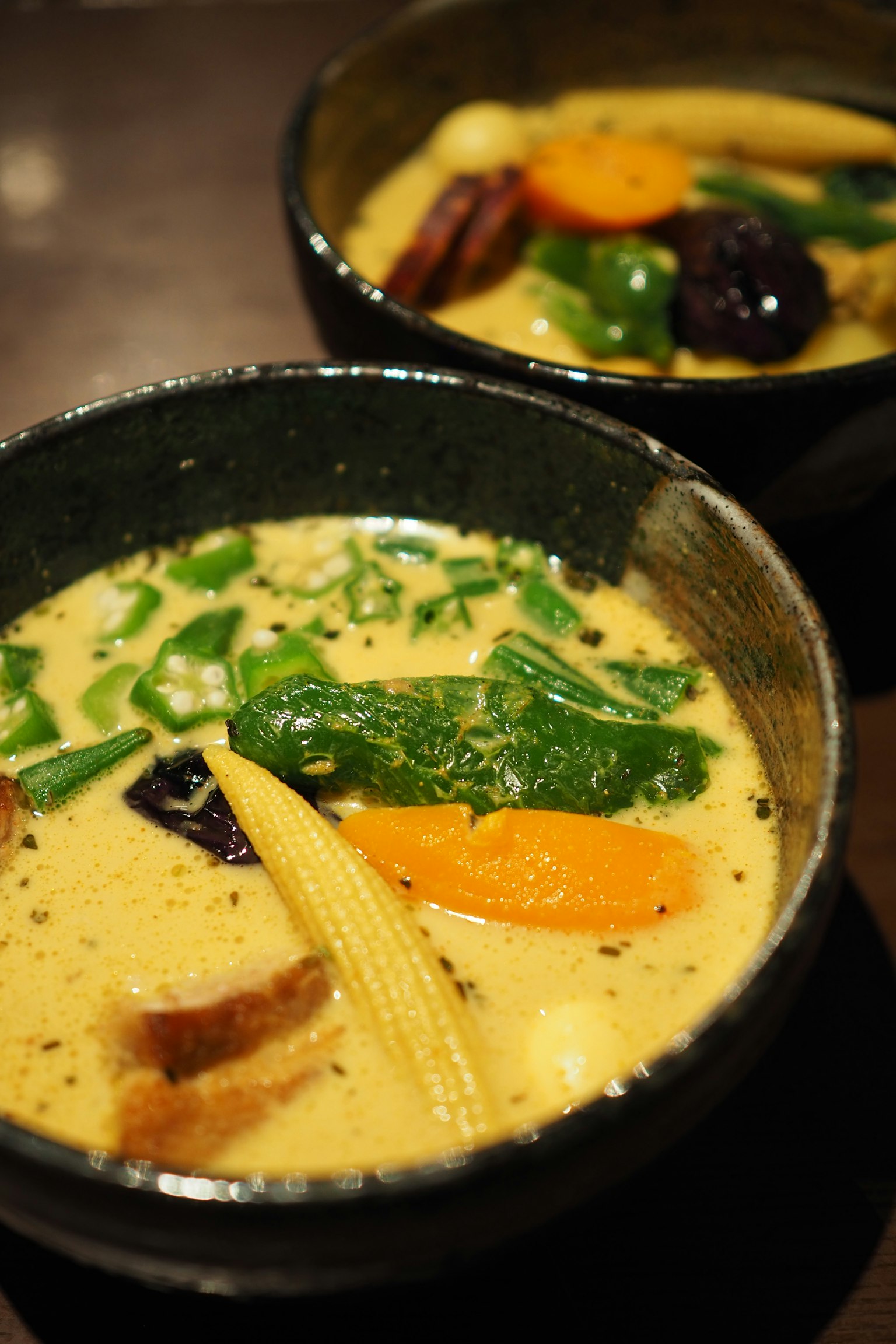 Creamy curry soup with colorful vegetables in bowls
