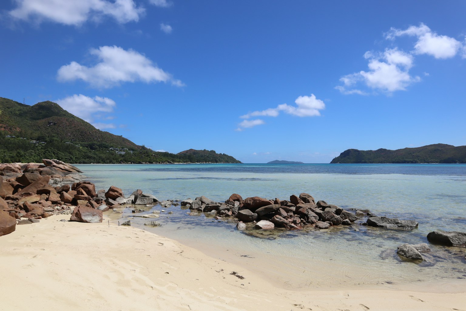 Vue de plage pittoresque avec mer et ciel bleus, vagues douces et rivage rocheux