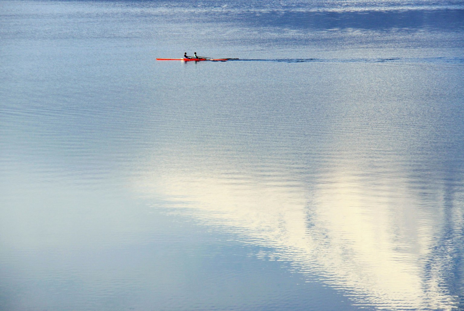 Une personne en kayak sur un lac calme avec des reflets