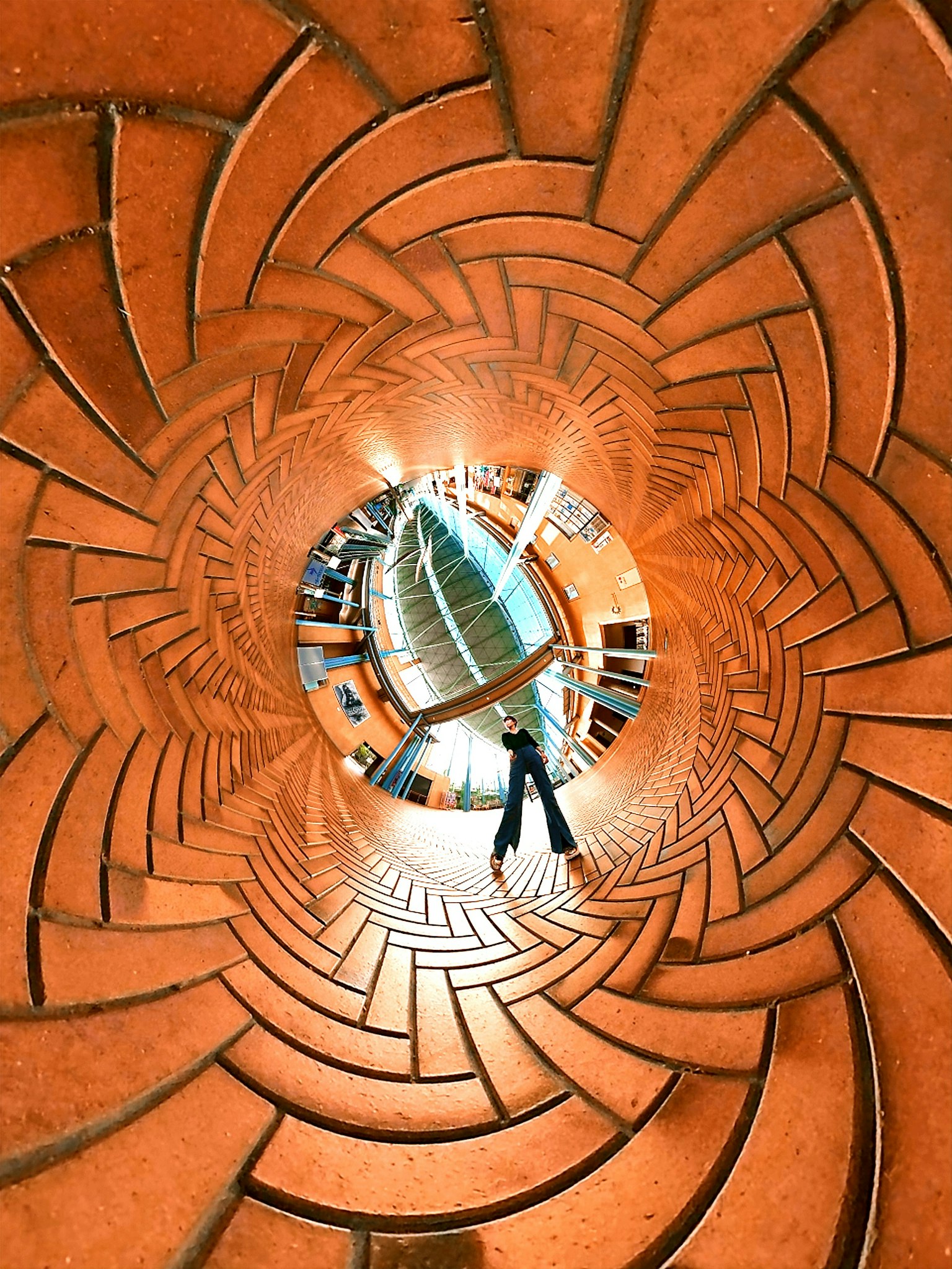 Imagen de una persona de pie en el centro de un túnel de azulejos circulares