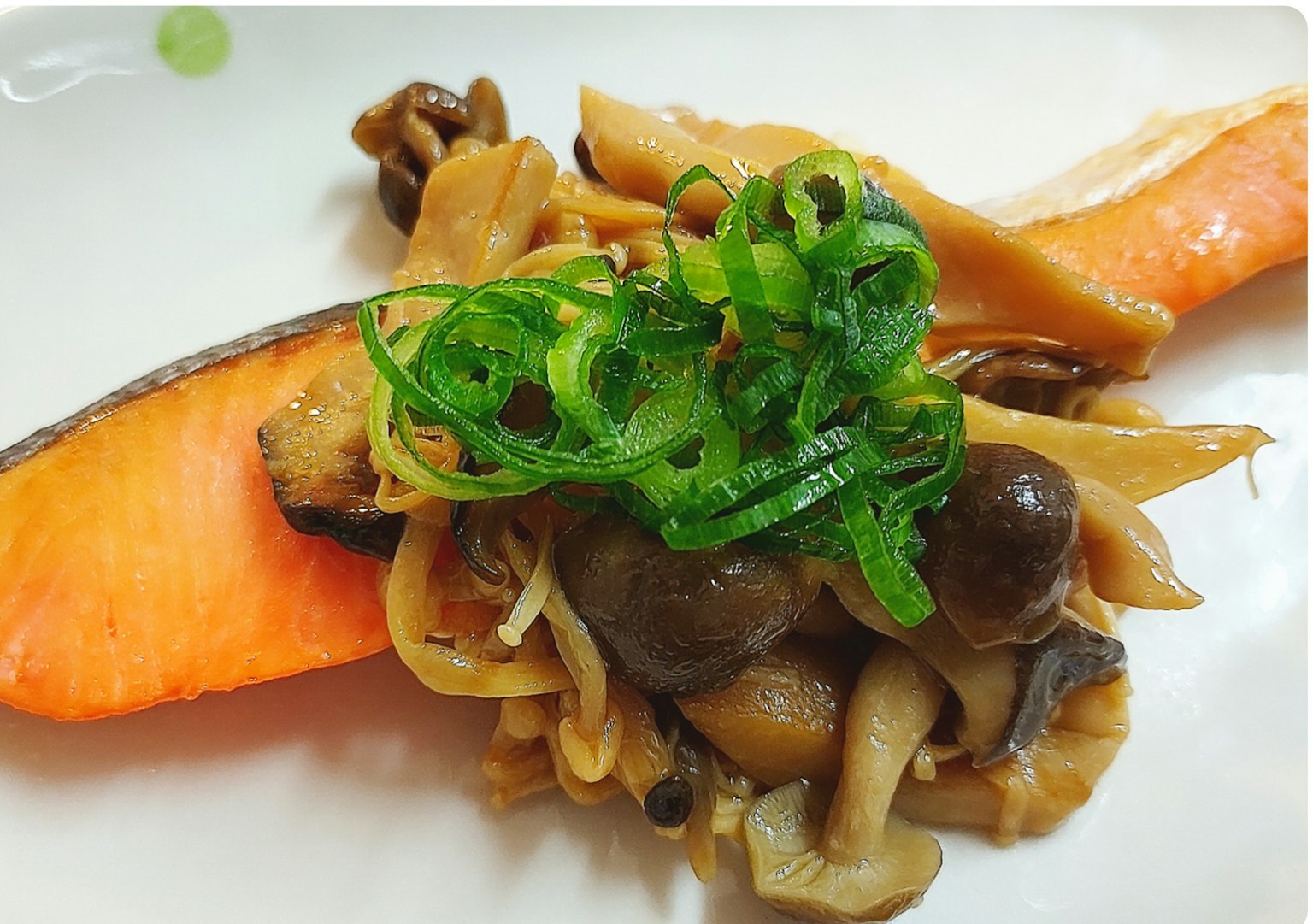 Plat avec du saumon et des champignons garni d'oignons verts