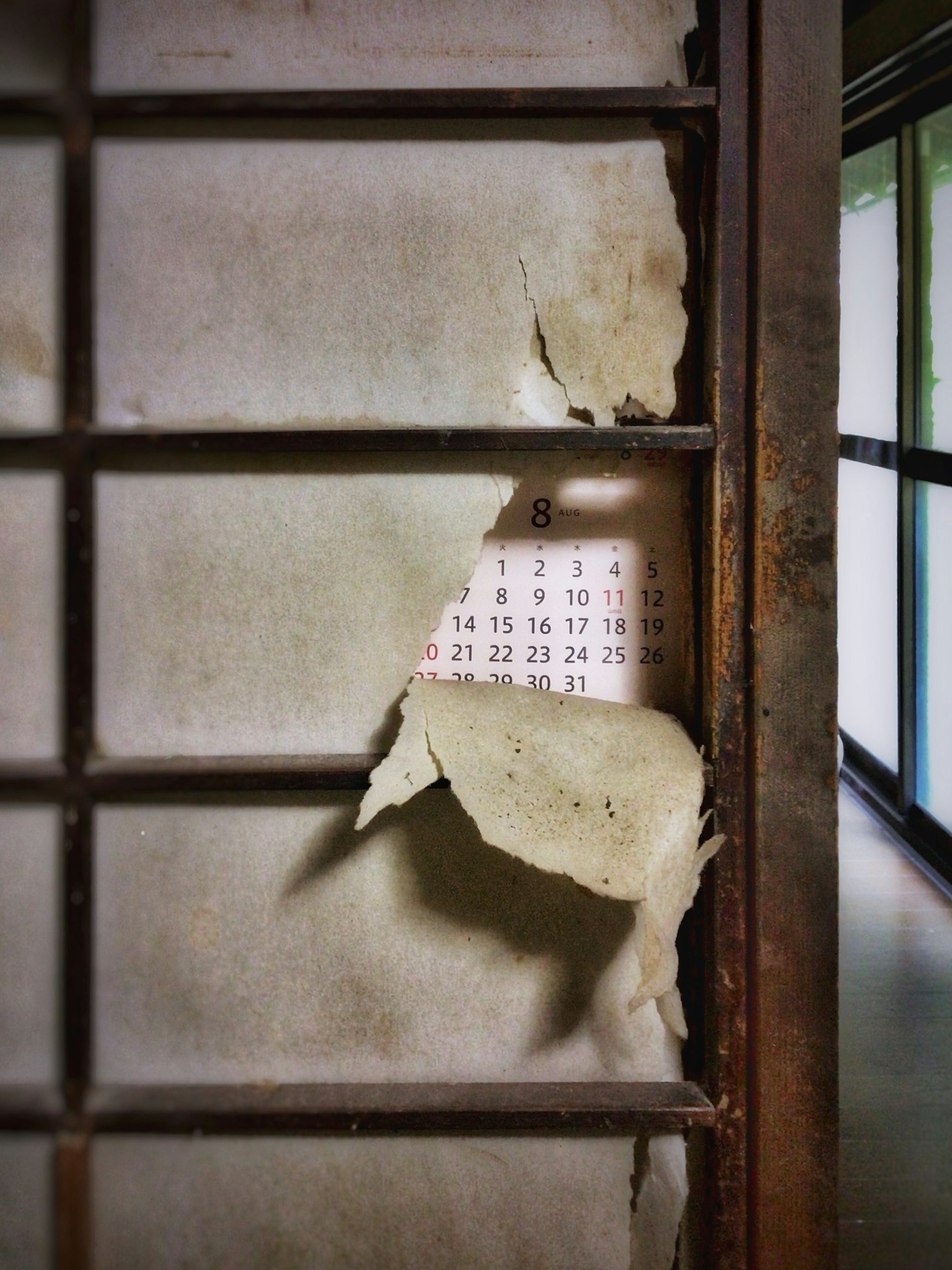 Mur en décomposition révélant un calendrier derrière