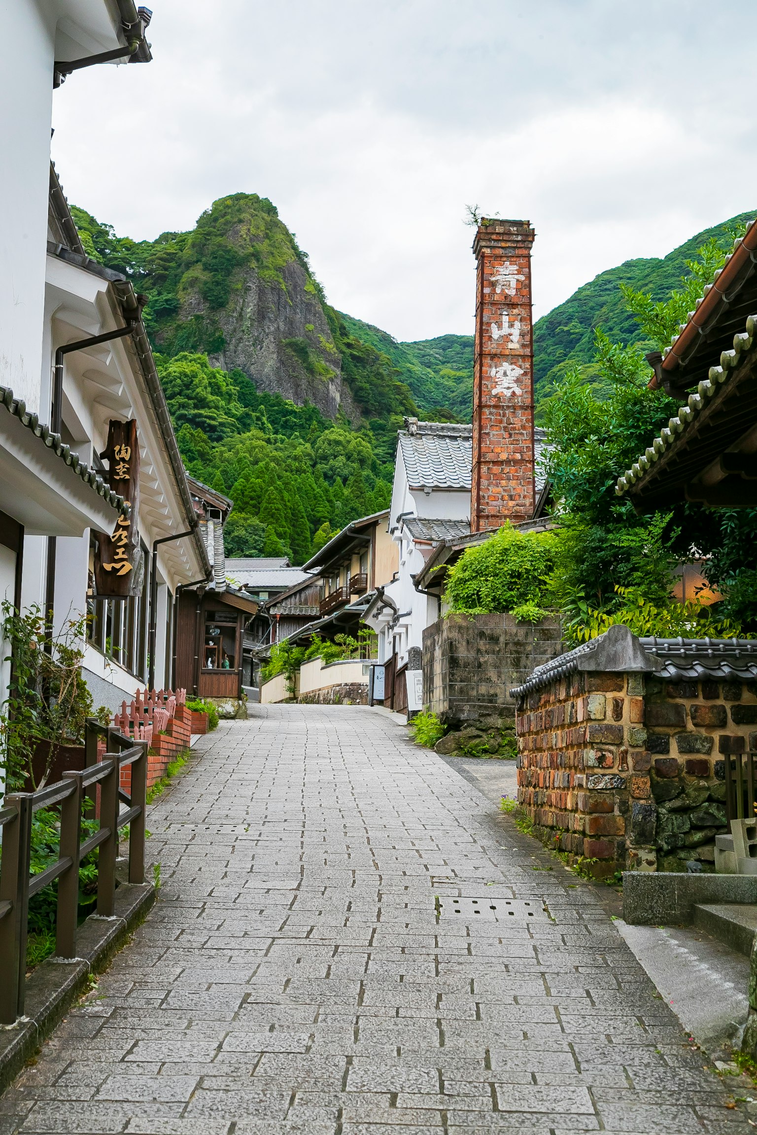 Scenic view of an old street surrounded by green mountains cobblestone path and traditional buildings