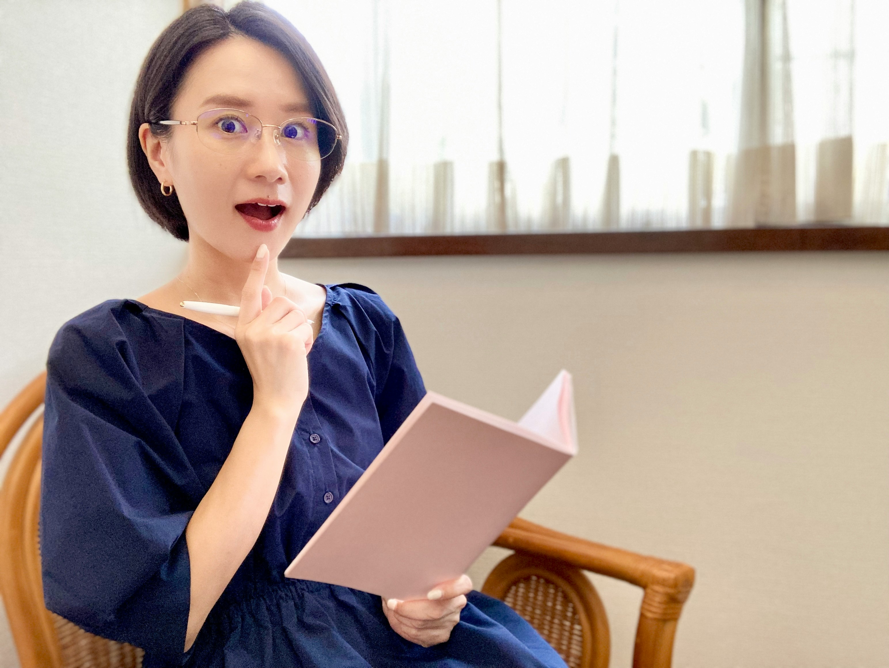坐在椅子上手拿书的女性在说话