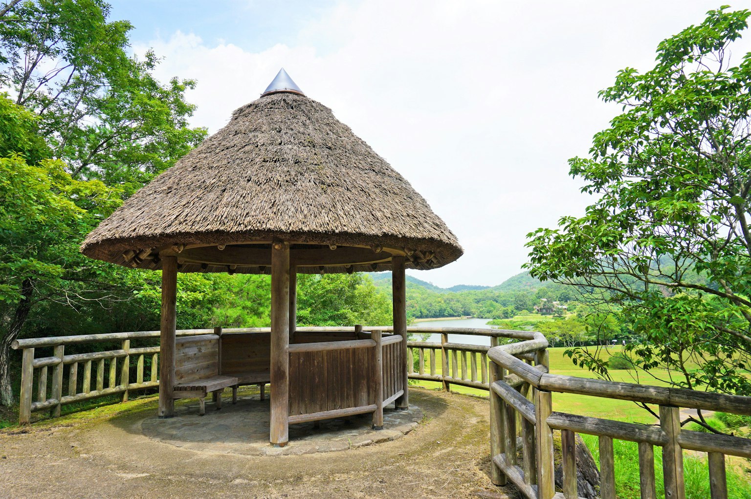 Gazebo de techo de paja rodeado de vegetación exuberante