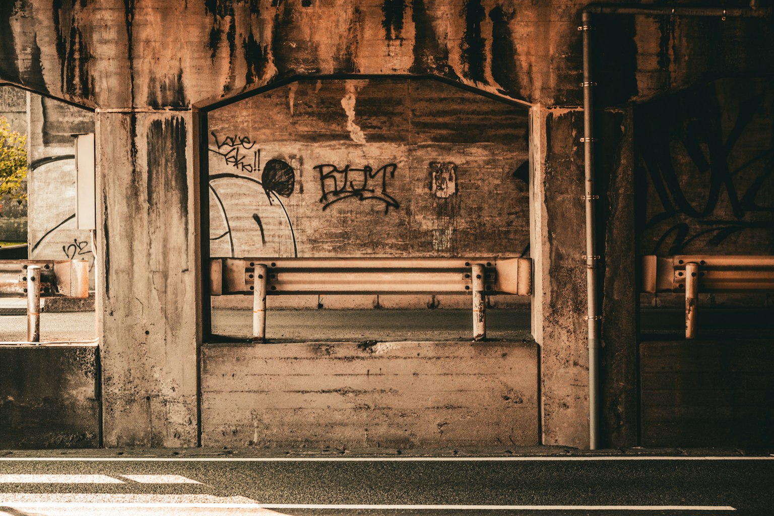 Foto eines Unterpasses mit Graffiti an Betonwänden und einer Betonbank