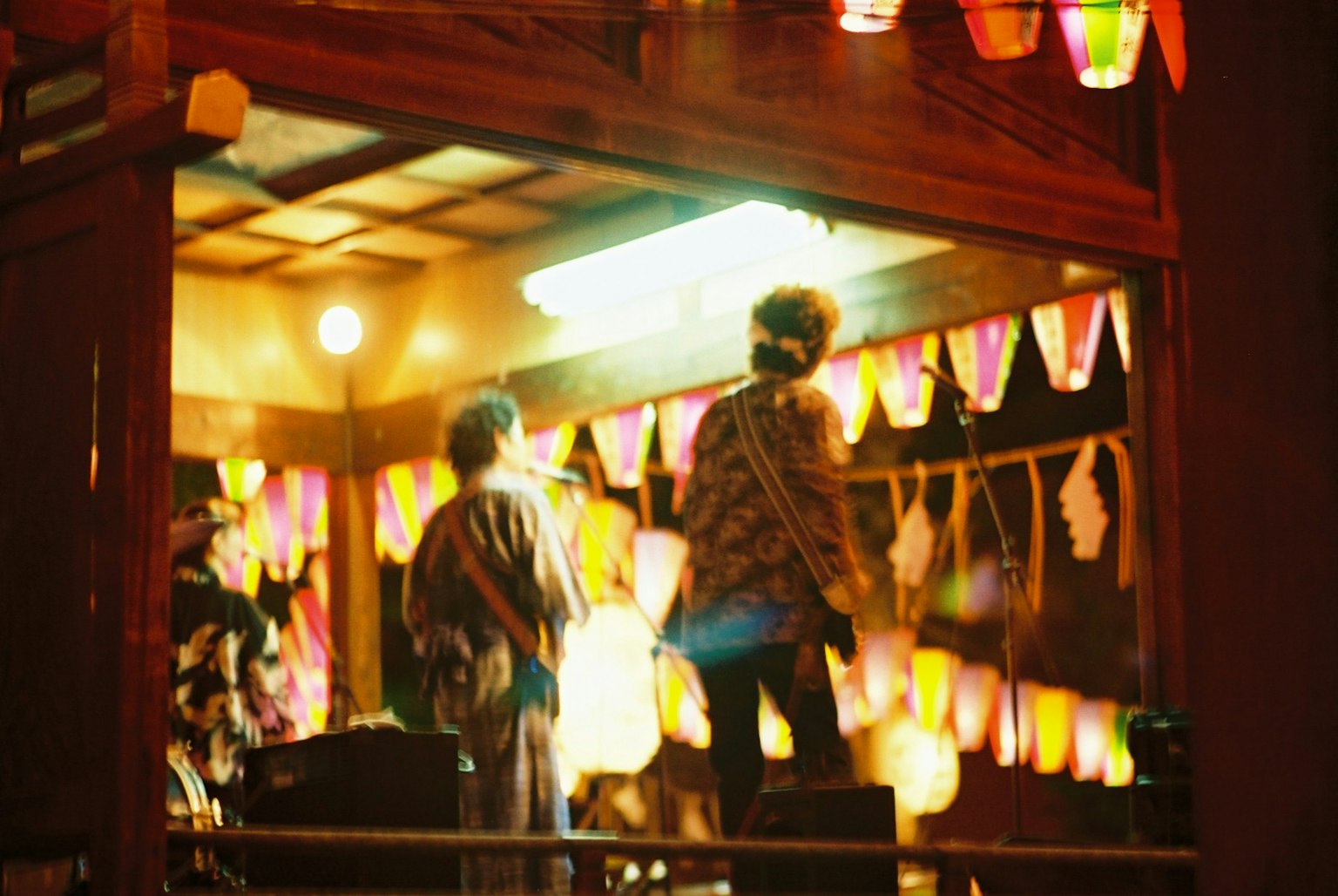 Dos figuras bailando en un festival nocturno Linternas coloridas y decoraciones en el fondo