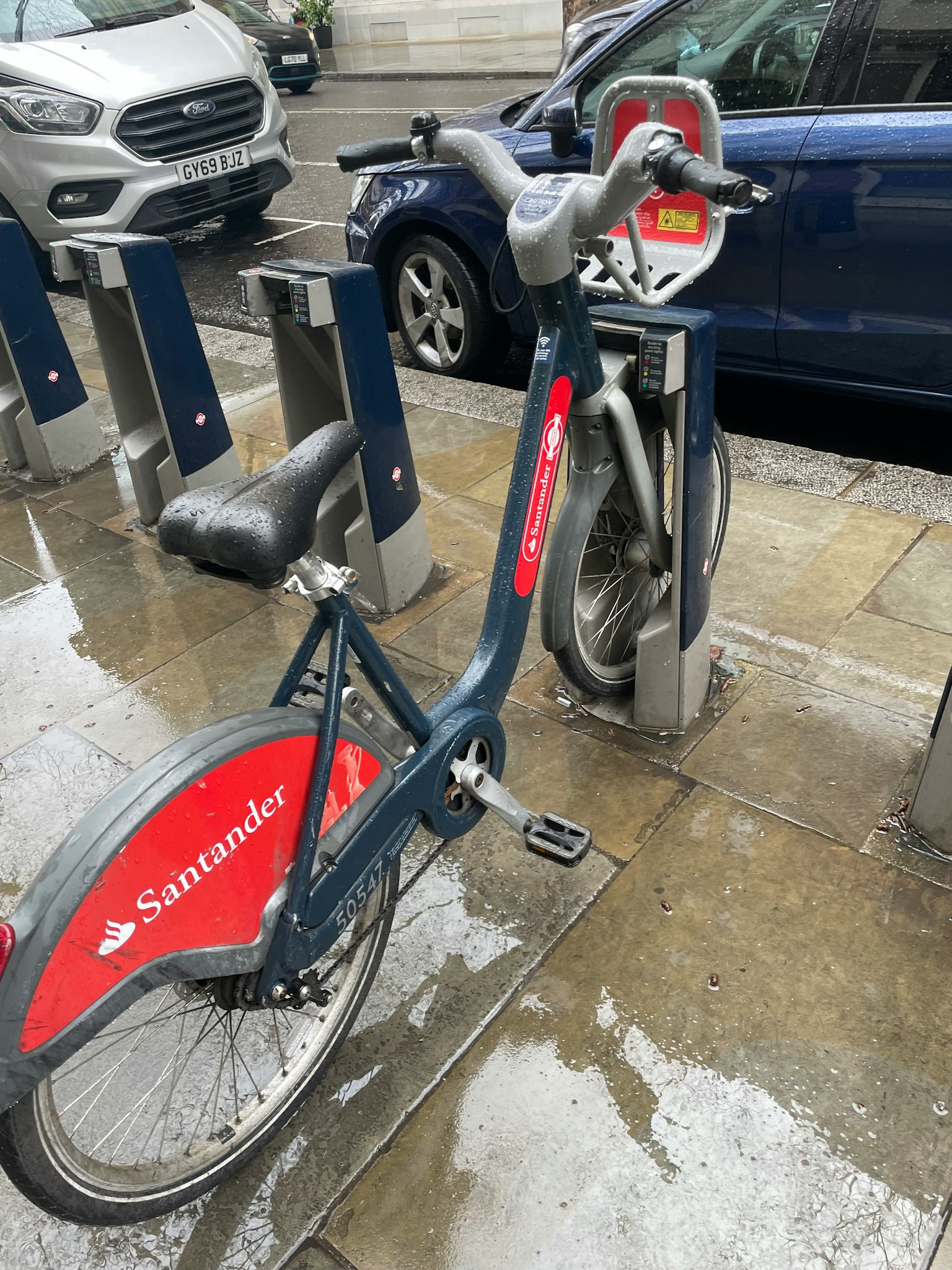 Bici Santander parcheggiata in una stazione di docking in una giornata di pioggia