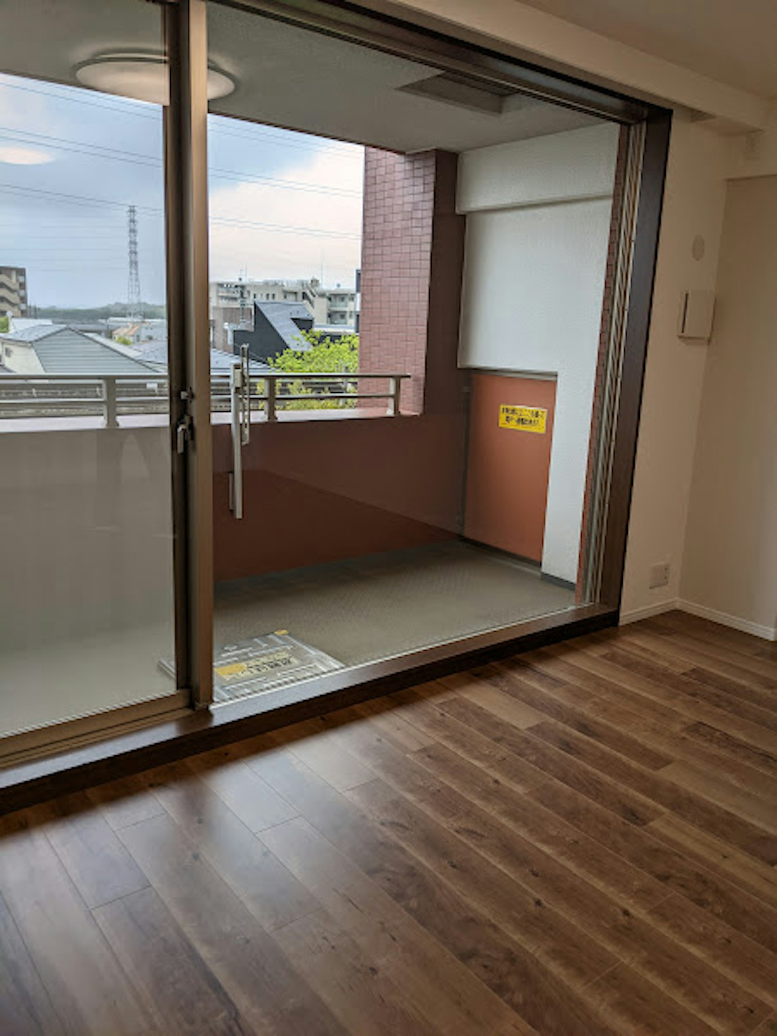 Sala luminosa con vista al balcón a través de grandes ventanas