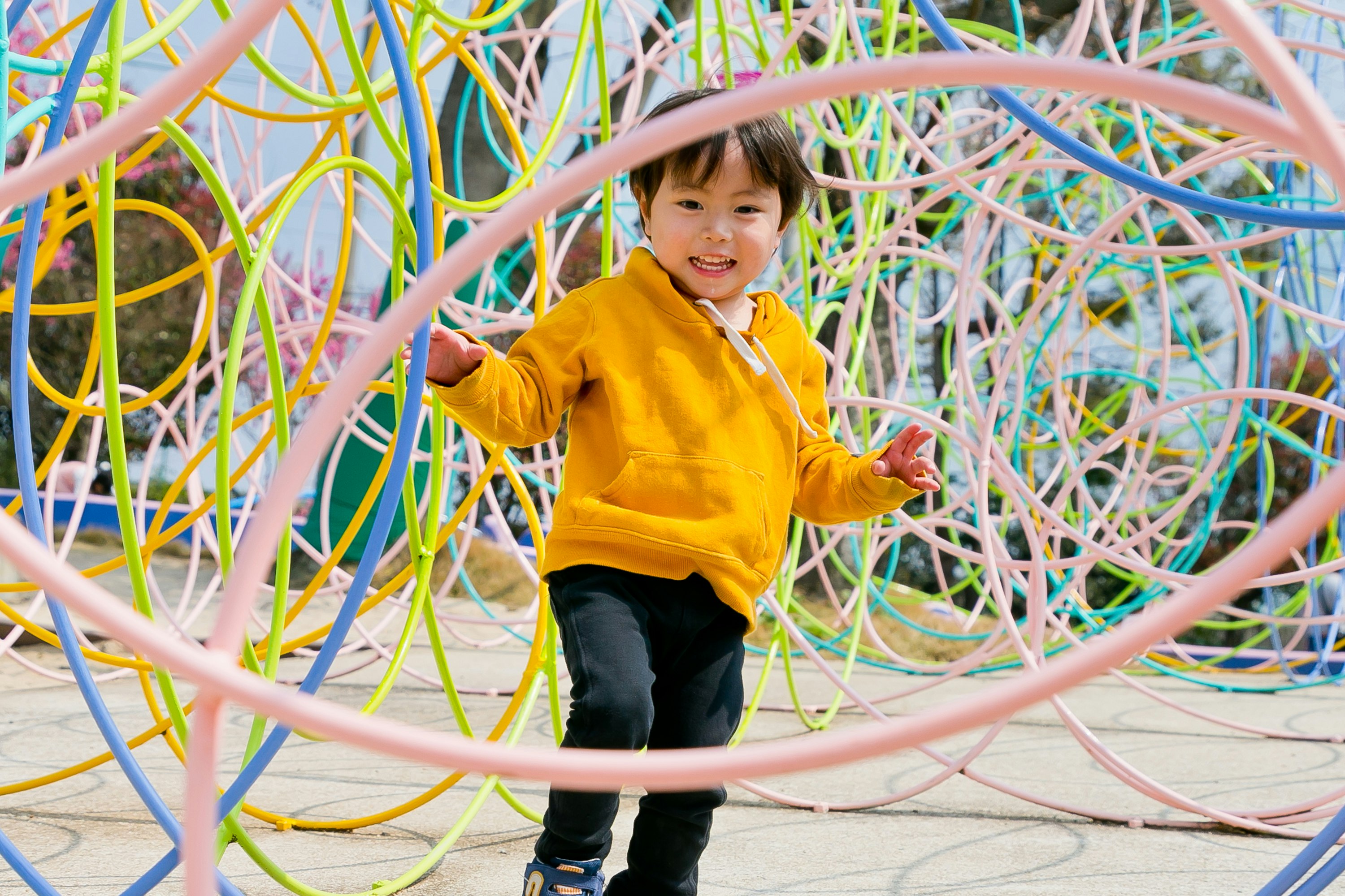 Smiling child inside colorful playground hoops