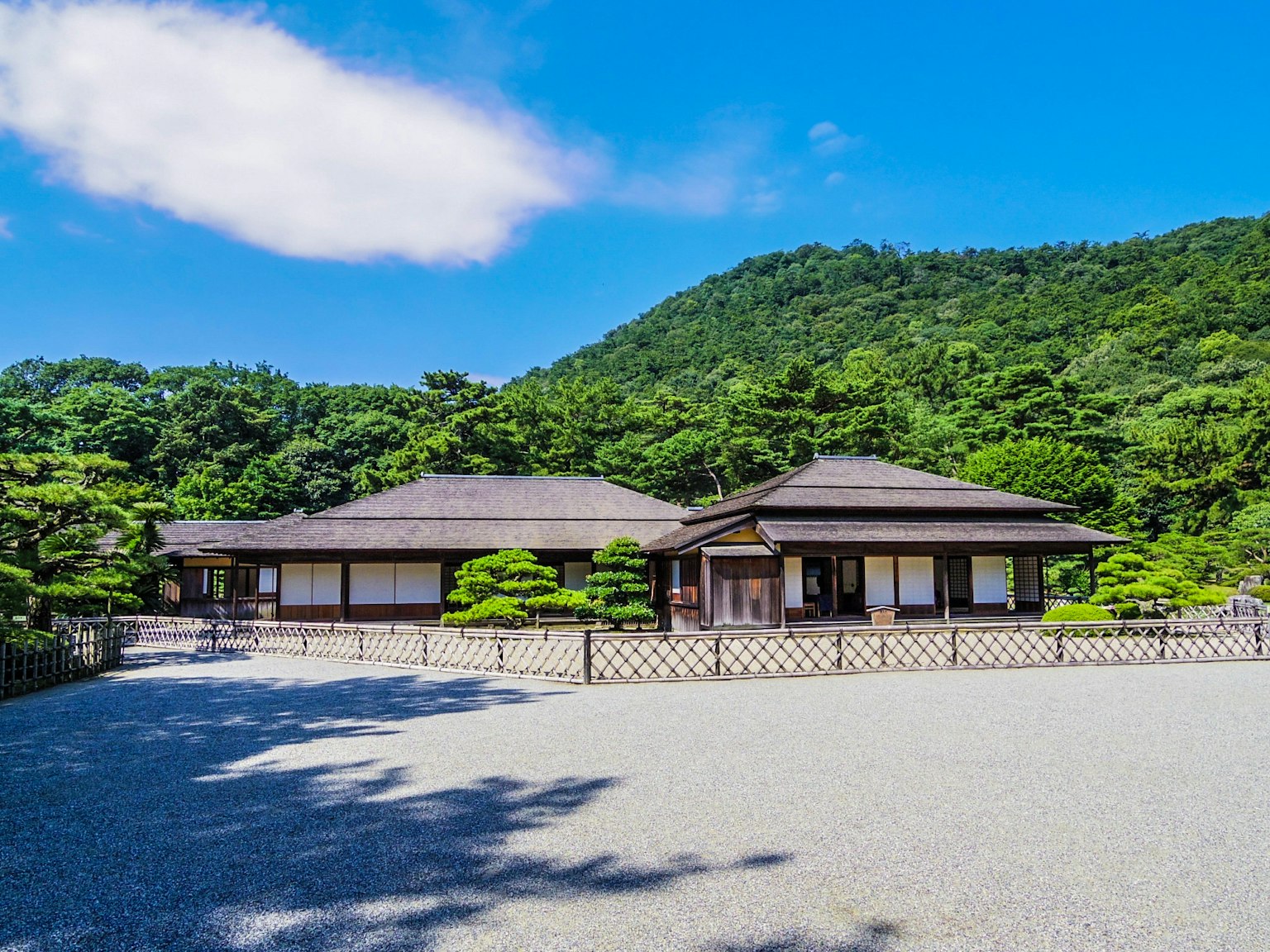 Rumah tradisional Jepang dikelilingi oleh pepohonan dan pegunungan