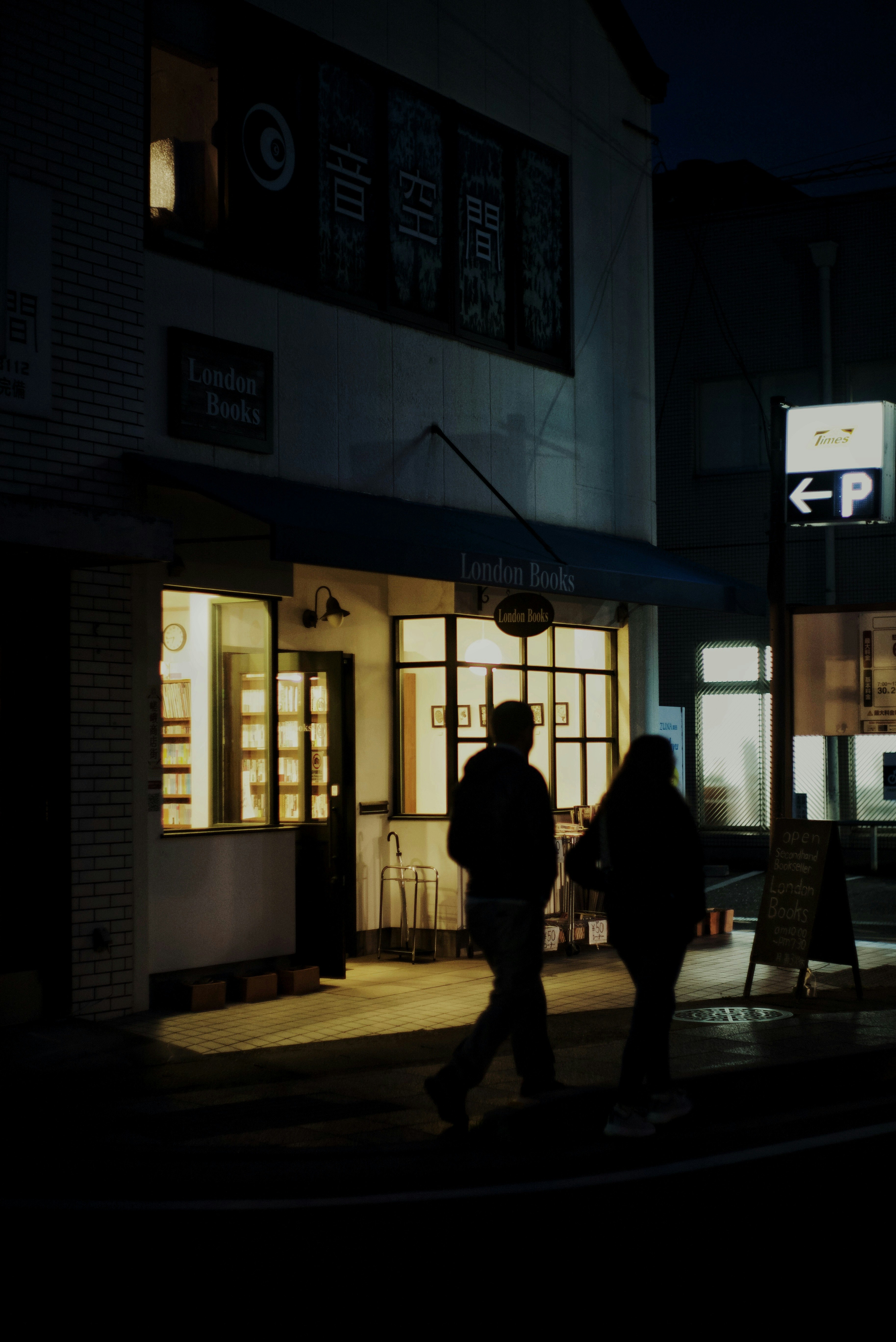 gang malam di Arashiyama dengan deretan lampu toko dan papan nama
