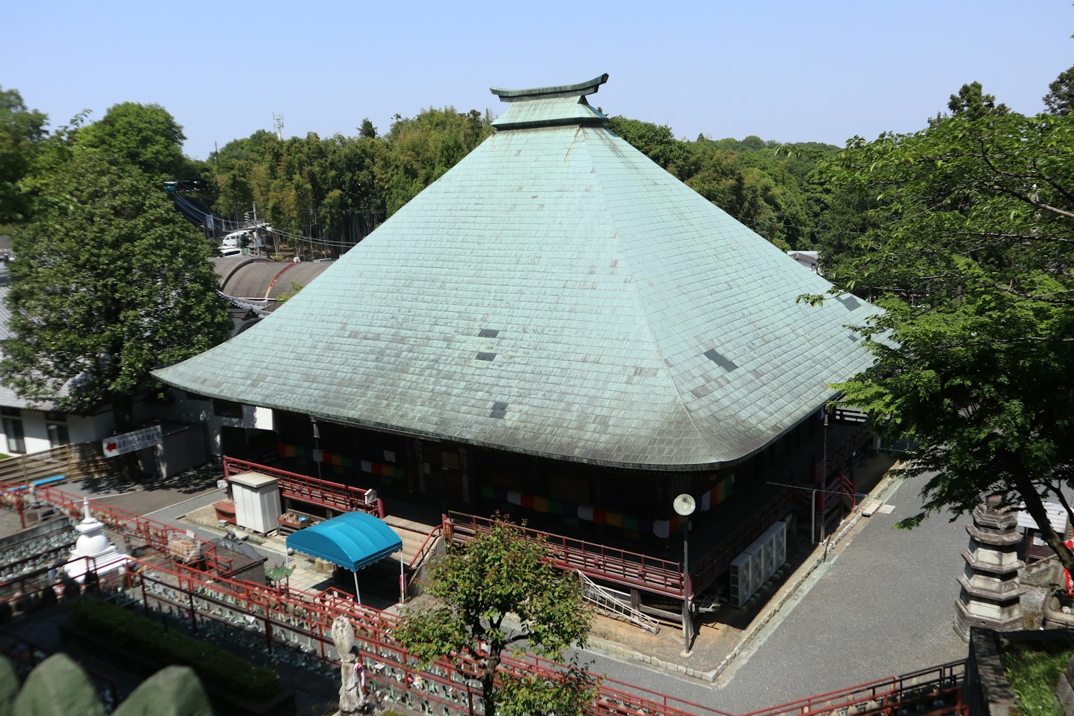 被绿树环绕的传统日本寺庙，特色为独特的青铜色屋顶